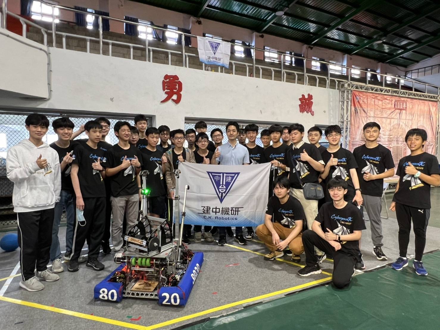 準台北市長蔣萬安今天以校友身分出席建中校慶，受邀至機器人研究校隊參觀，大讚學弟們好厲害，與師生合影留念。（讀者提供）