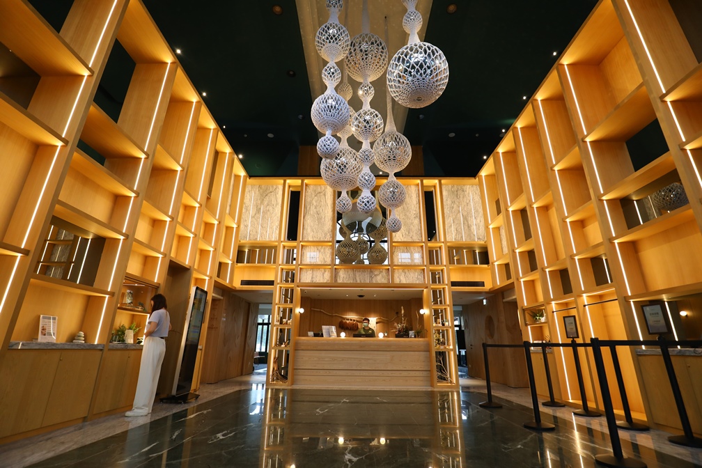 大廳的藝術裝置《尋光種子》出自花蓮編織工藝家之手,以織物纏繞鏡面球體,透過鏡子反射出光的萬千變化。