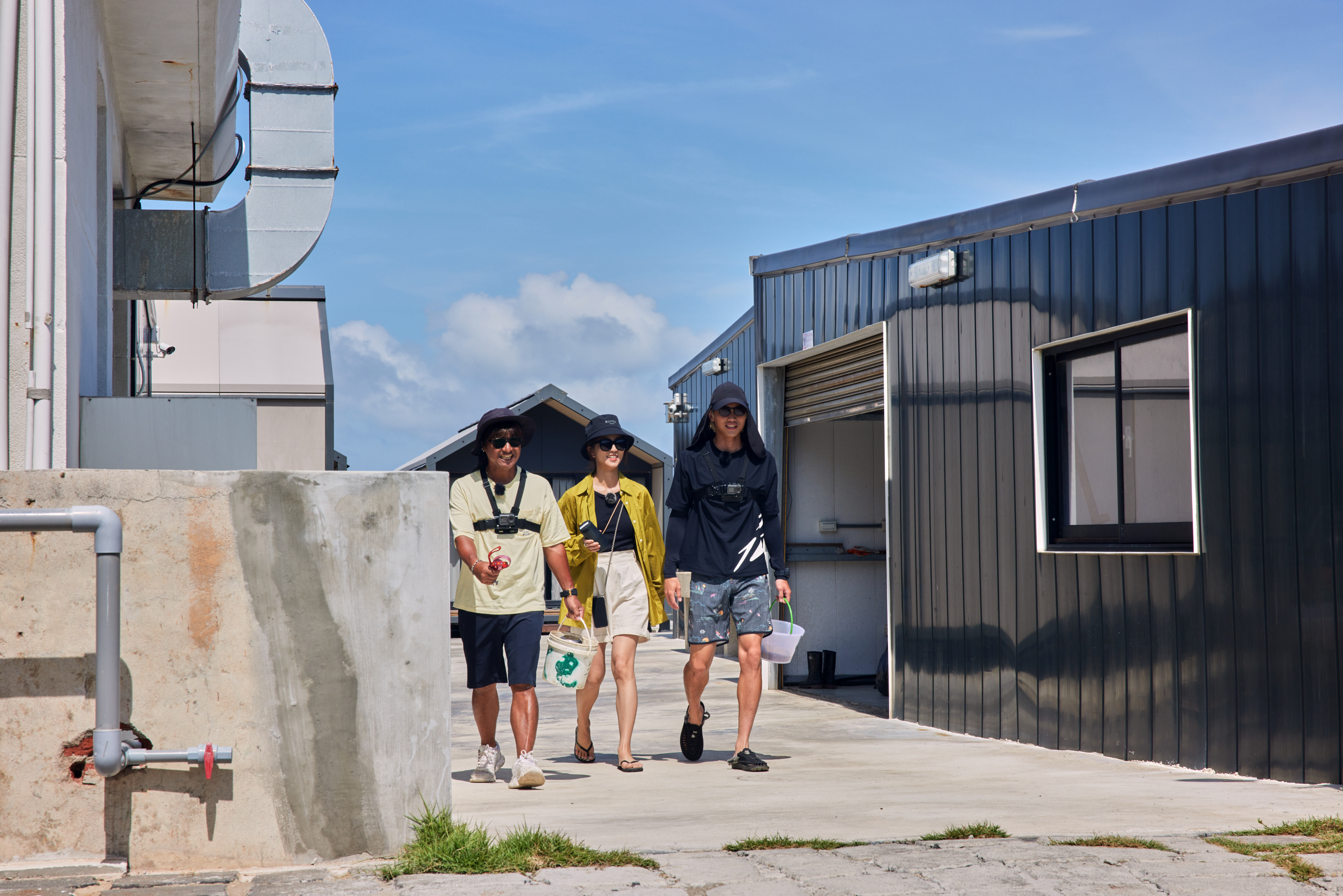 尤秋興（左）、范少勳（右）帶著周曉涵參觀「再生社區」。（灰人文化提供）