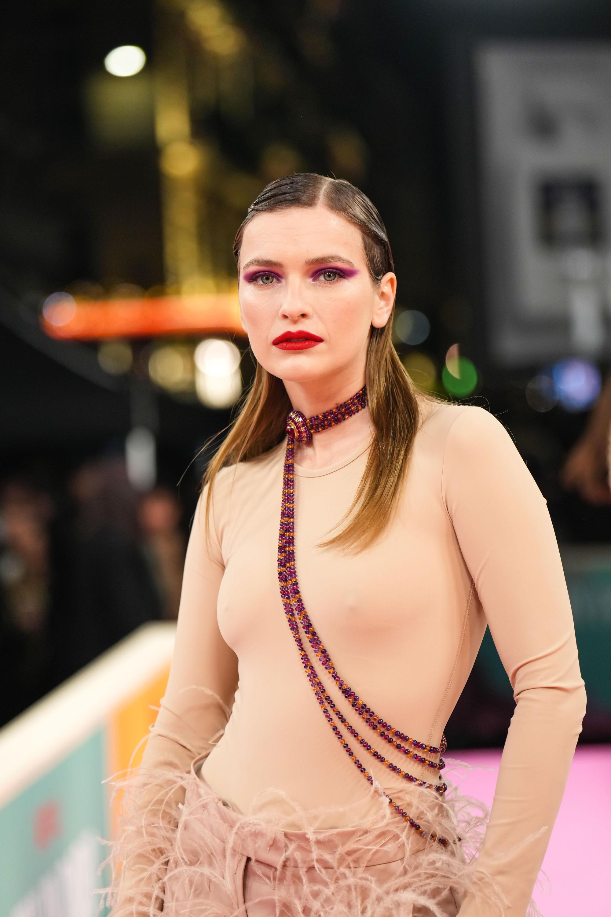 卡蜜兒塞拉萊穿著肉色貼身上衣,下半身搭配羽毛長褲。(Netflix提供)