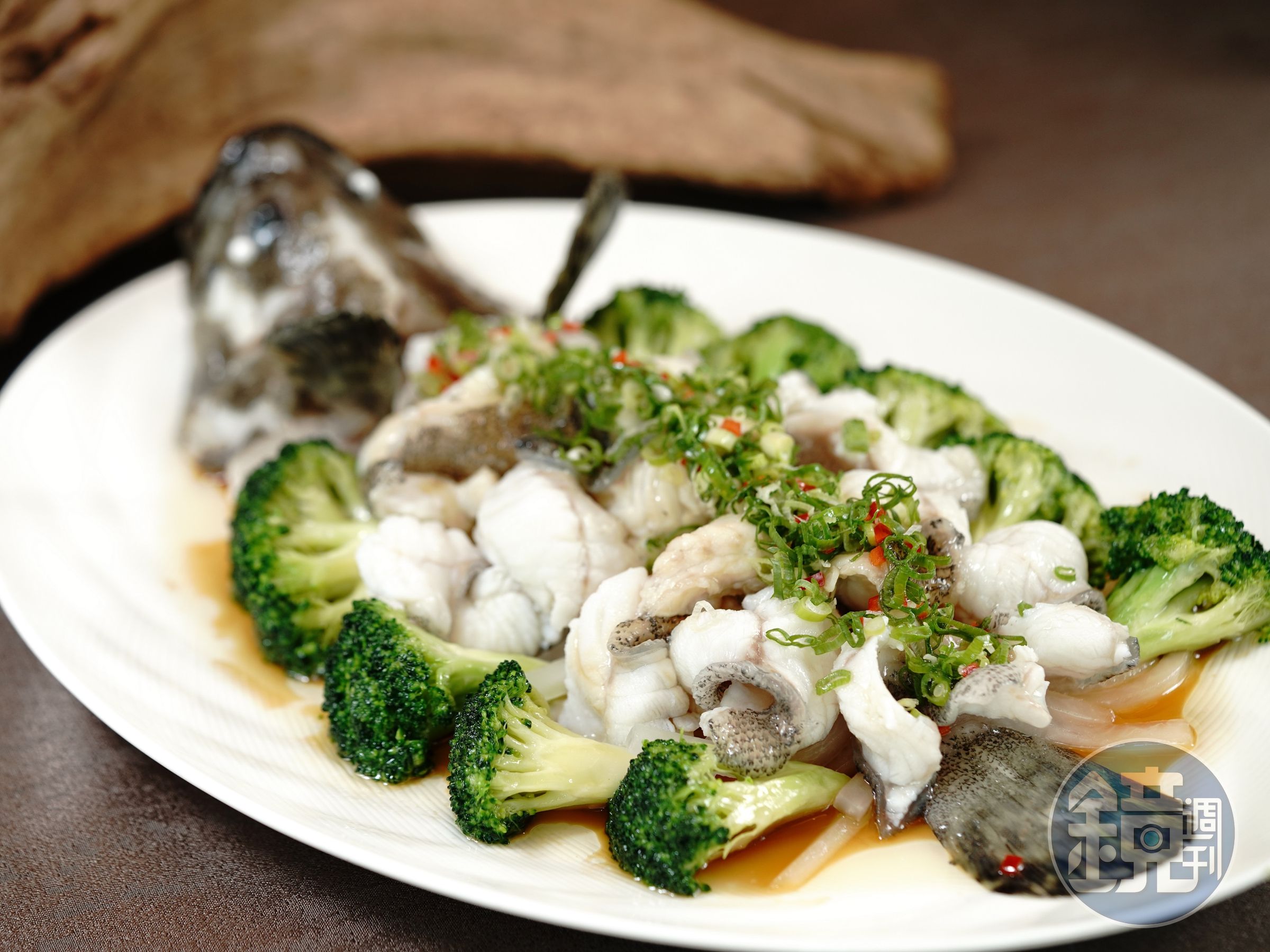 「蔥油淋魚」貼心剔除骨頭和刺，老虎斑肉質Q彈，盤底的蒸魚醬油淋飯更是一絕。（聚苑提供）