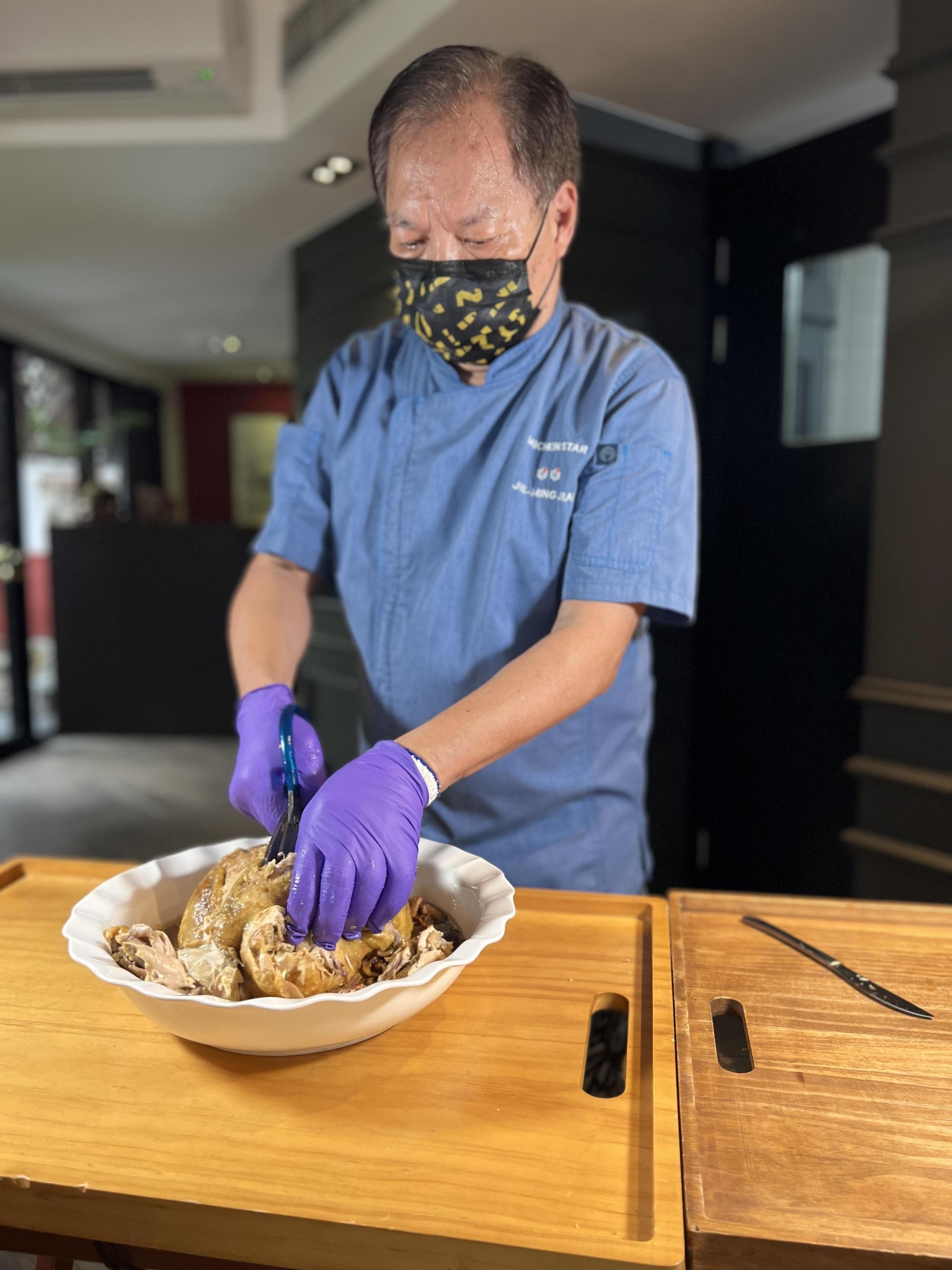 簡師傅親自示範「火焰富貴雞」在桌邊脫「衣」的過程。