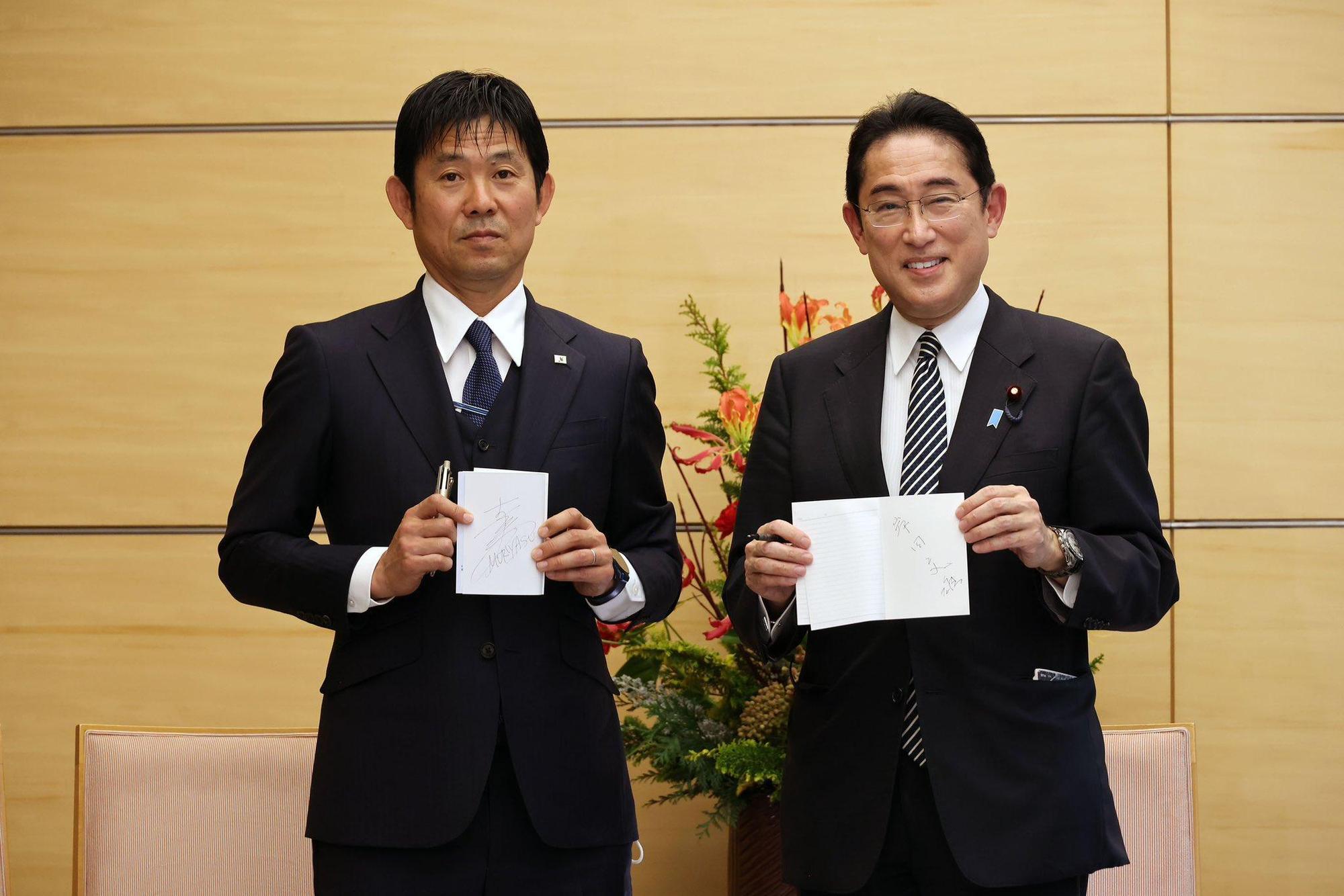 日本首相岸田文雄(右)與足球國家隊教練森保一(左)互相交換了筆記本。(翻攝自岸田文雄Twitter)