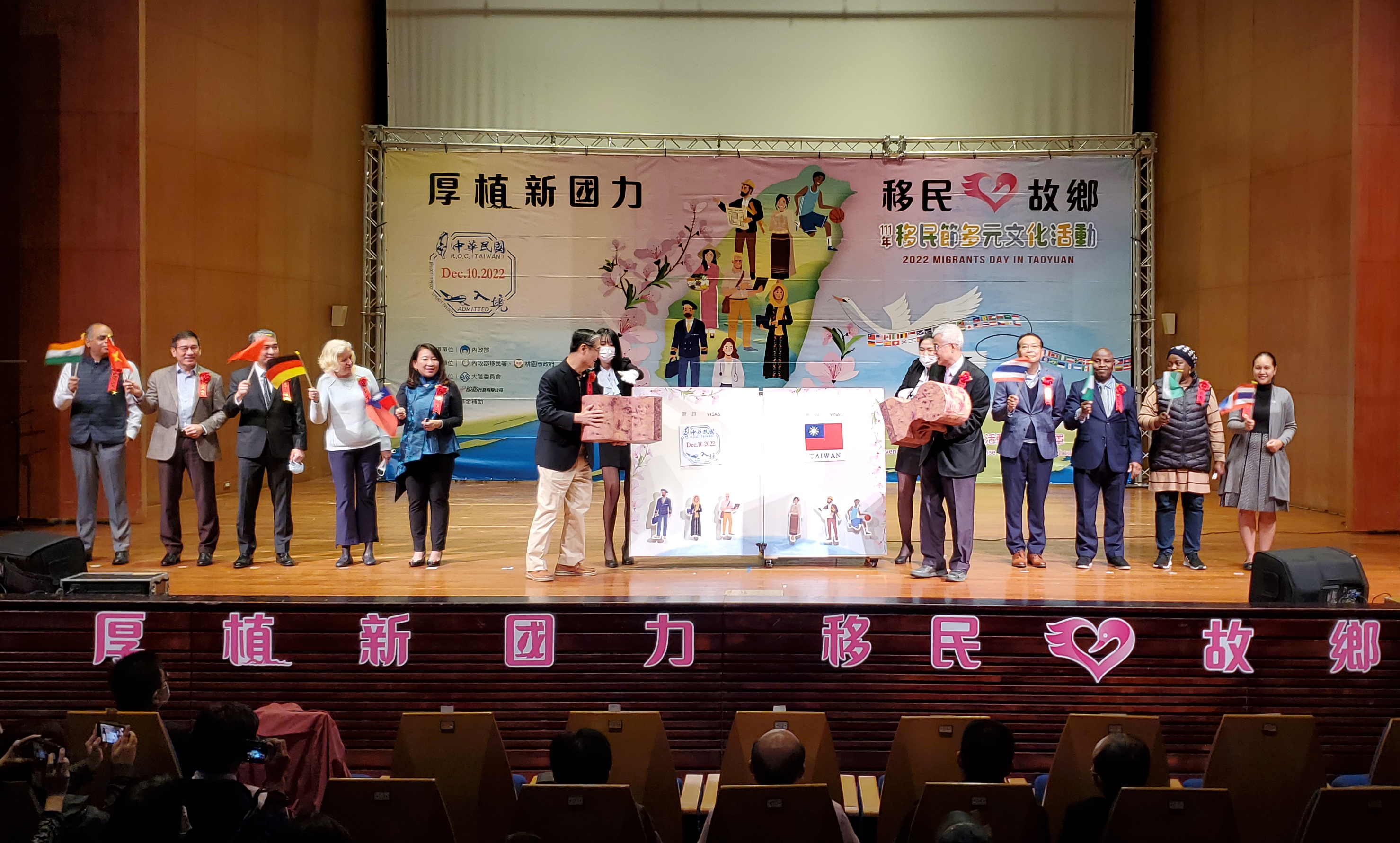 移民署署長鐘景琨（左6）與桃園市副市長李憲明（右5），分別於魔法書上蓋下象徵中華民國入境查驗章及國旗，揭開移民節活動序幕。（移民署提供）