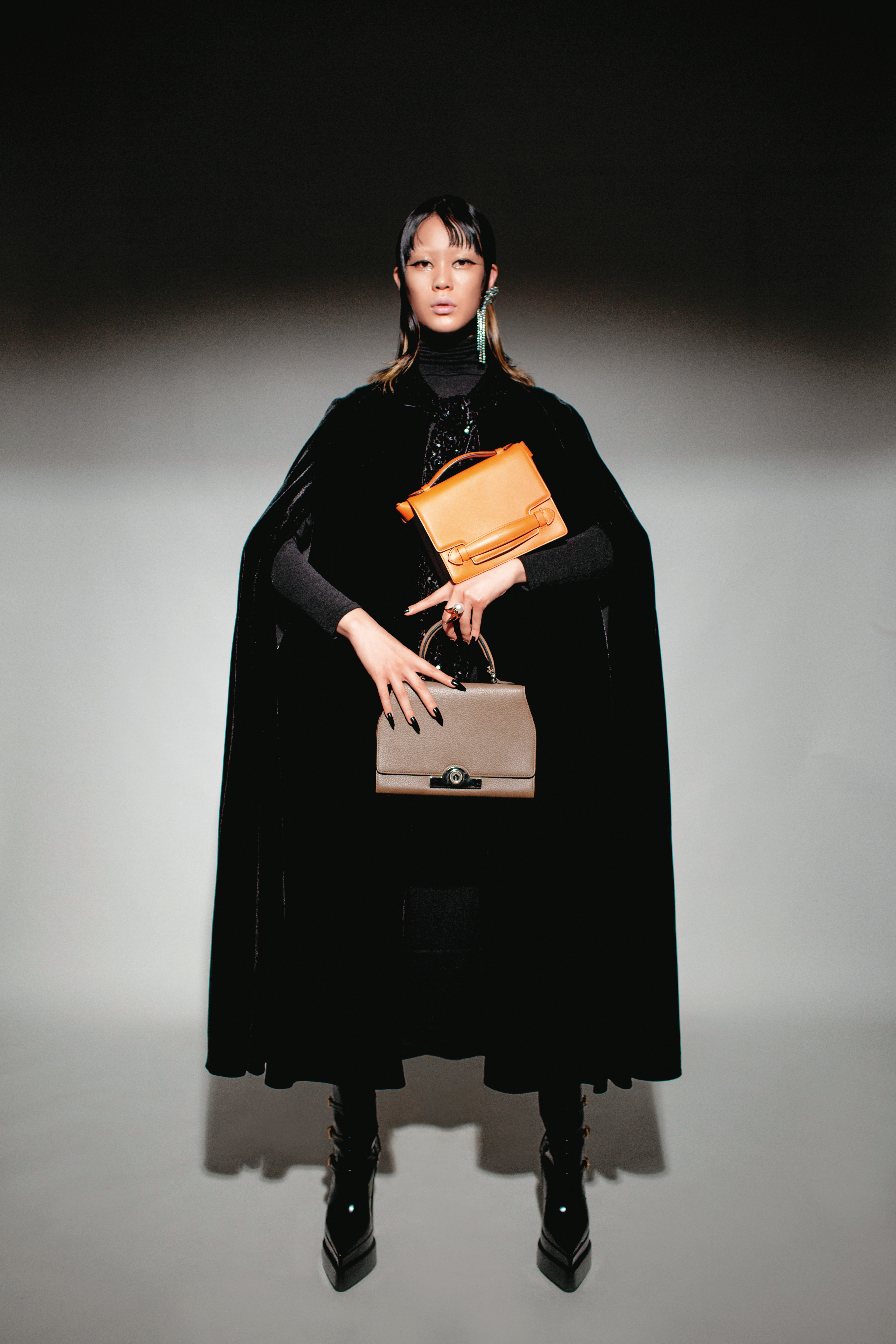 (上)旱金蓮橘Sac Malle包 NT$147,000、(下)斑鳩灰Rejane BB包 價格店洽 by Moynat/黑色亮天鵝絨片斗篷 NT$3,490 by ZARA/黑色長袖上衣 私物 黑色尖頭粗跟高跟鞋 NT$62,000 by VERSACE/水鑽耳環 NT$790 by ZARA