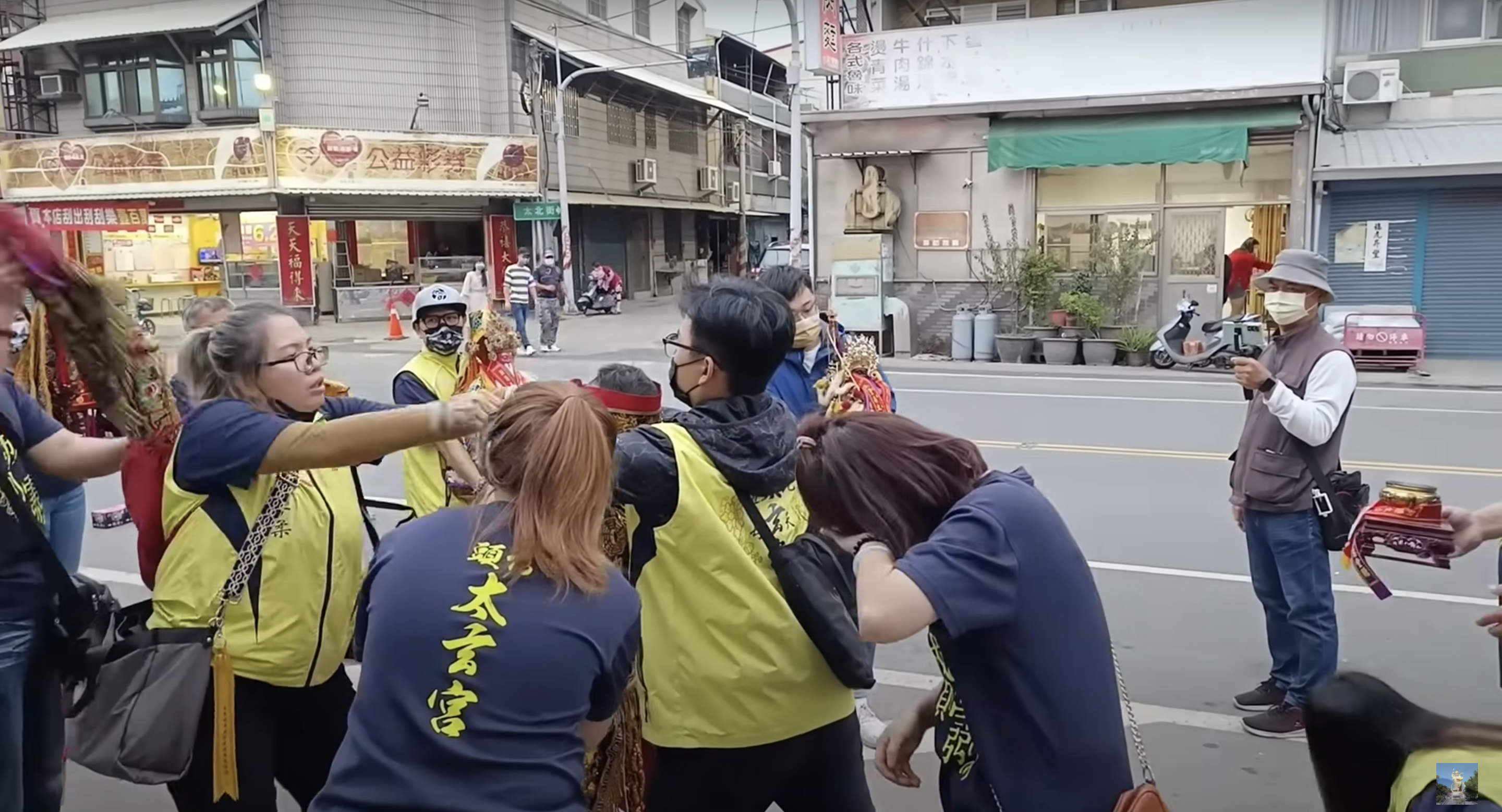 女信徒(右)被賞巴掌後,頻頻擦拭眼睛,不清楚是否為痛到流淚或是傷到眼睛。(翻攝自YouTube)