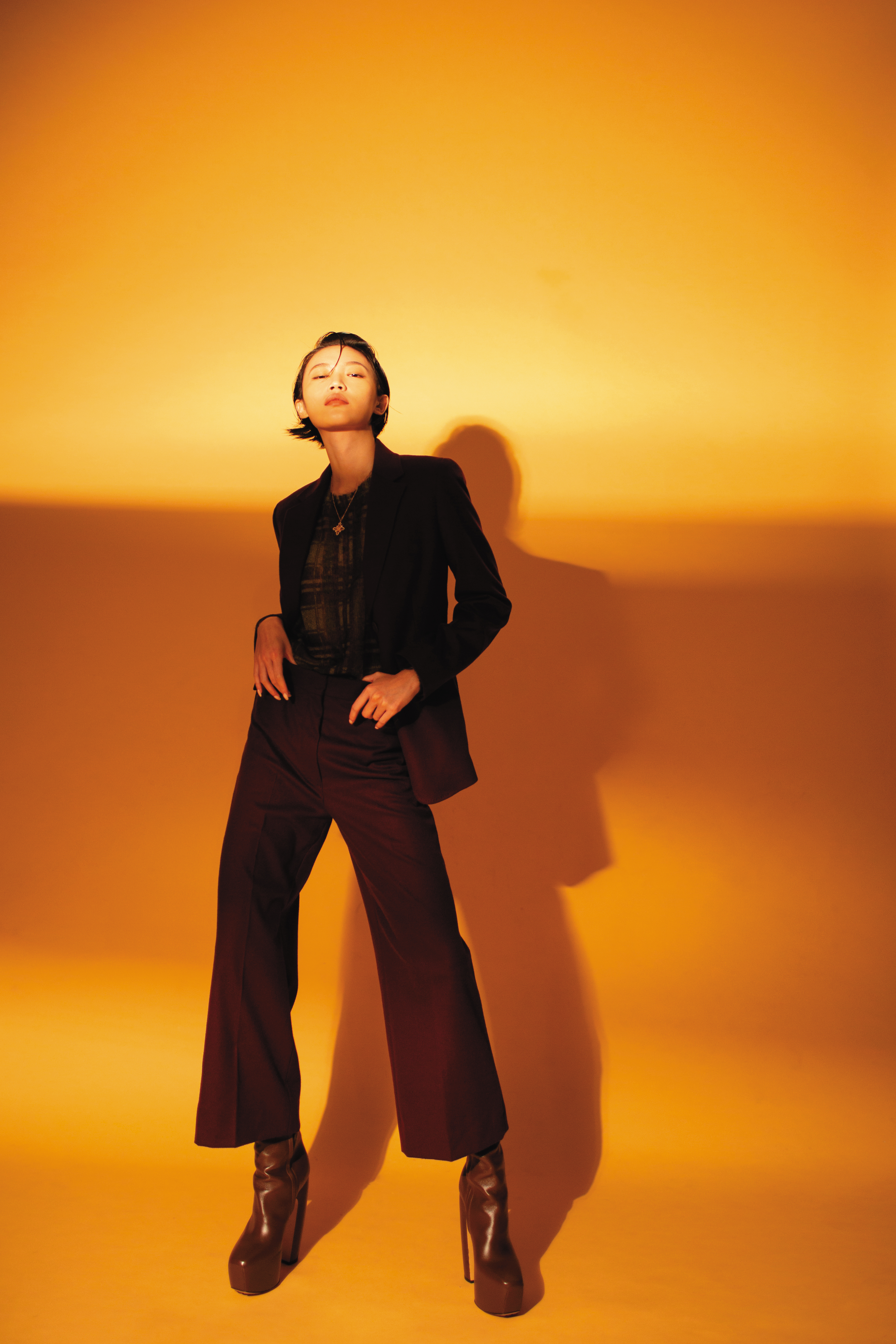 紫紅色修身長褲 NT$20,800 by Max Mara；紫紅色西裝外套 NT$45,800 by Max Mara；透膚格紋內搭 NT$26,800 by Max Mara；深棕色高跟長靴 價格店洽 by BOTTEGA VENETA；Wulu Legend系列18K玫瑰金鑲鑽紅寶石項鍊 NT$185,500 by Qeelin。