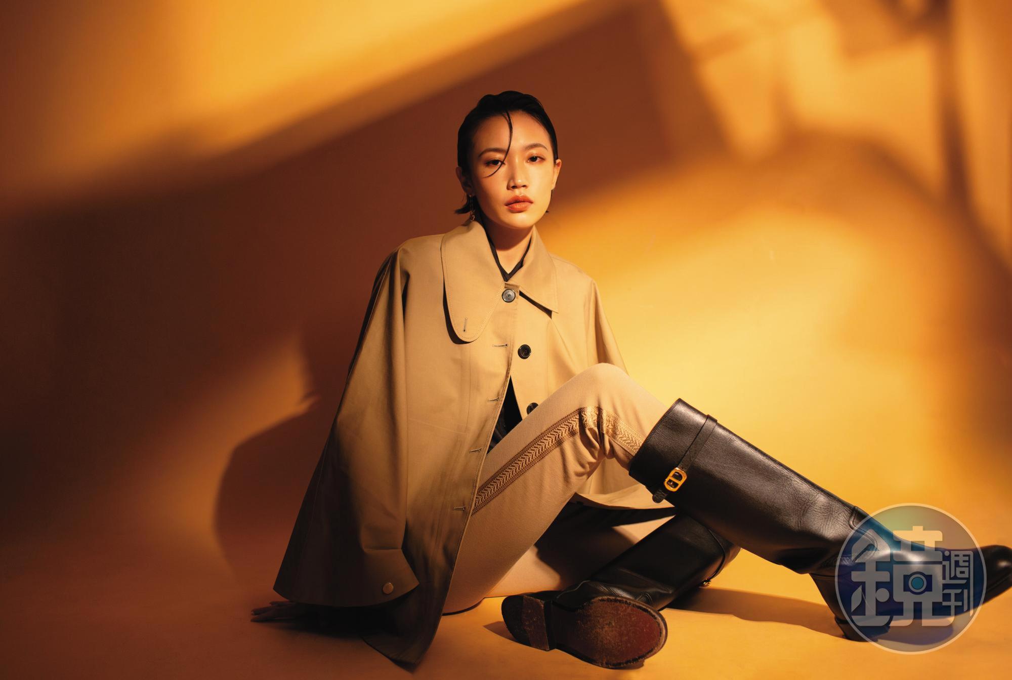 米色長褲 NT$43,000 by DIOR；米色全棉斗篷 NT$150,000 by DIOR；黑色襯衫 NT$72,000 by DIOR；小牛皮長筒馬靴 NT$72,000 by DIOR；Open Yu Yi 18K玫瑰金鑽石耳環	 NT$95,000 by Qeelin。
