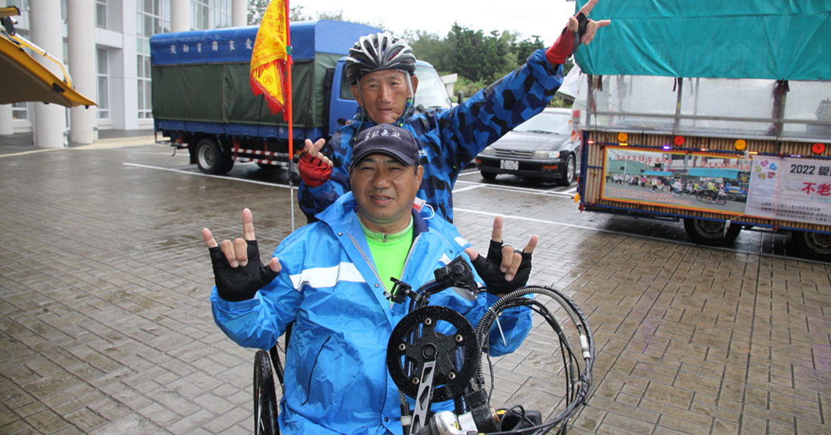 陳明瑟和不老志工一起比出車隊招牌的「我愛你」手勢，他覺得人生就很像自己第一次爬上那台小三輪車，隨時充滿希望。