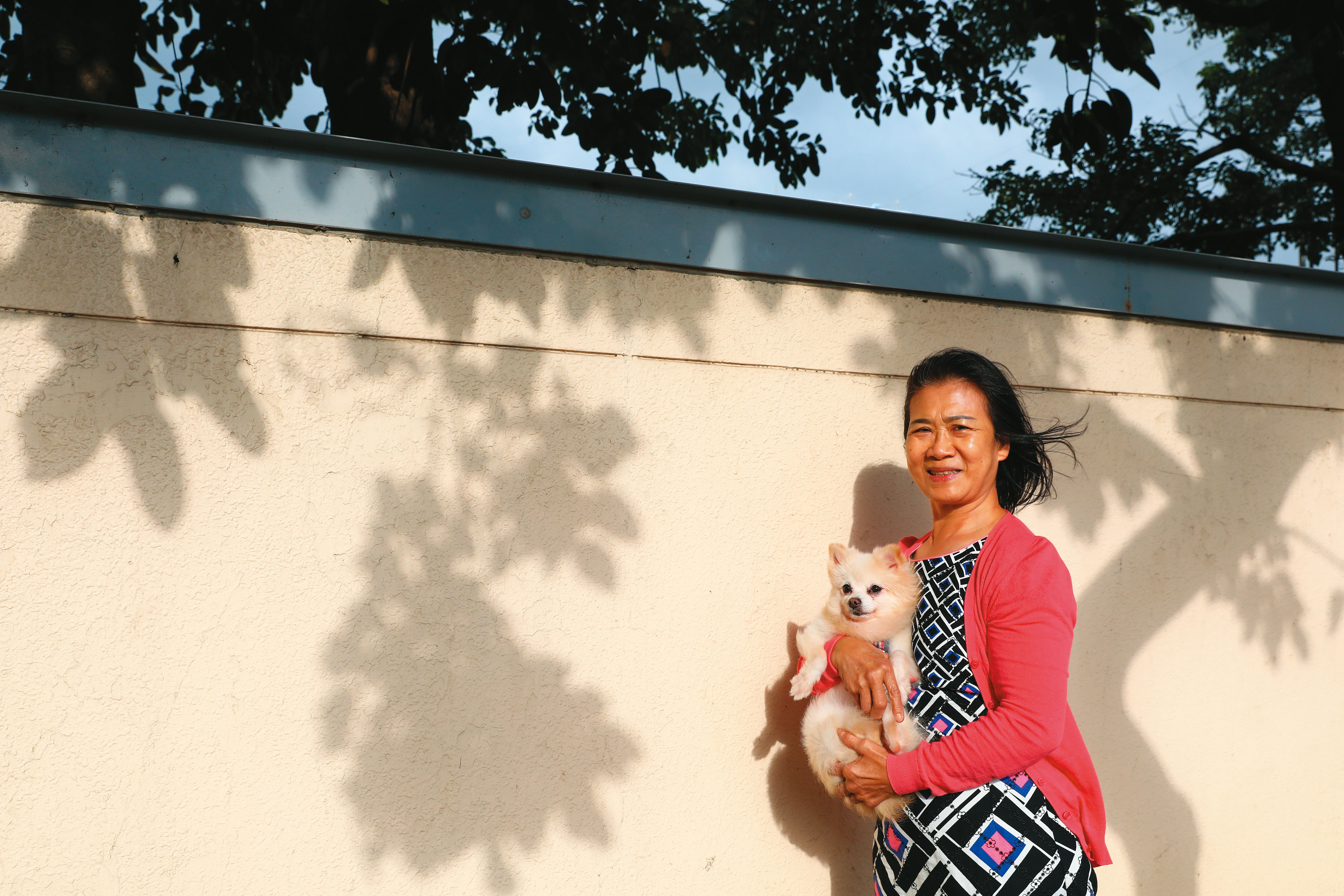退休後第一次回到廠區，阿嬌抱著愛狗「哈哈」，心情和當日天氣一樣雨過天青。