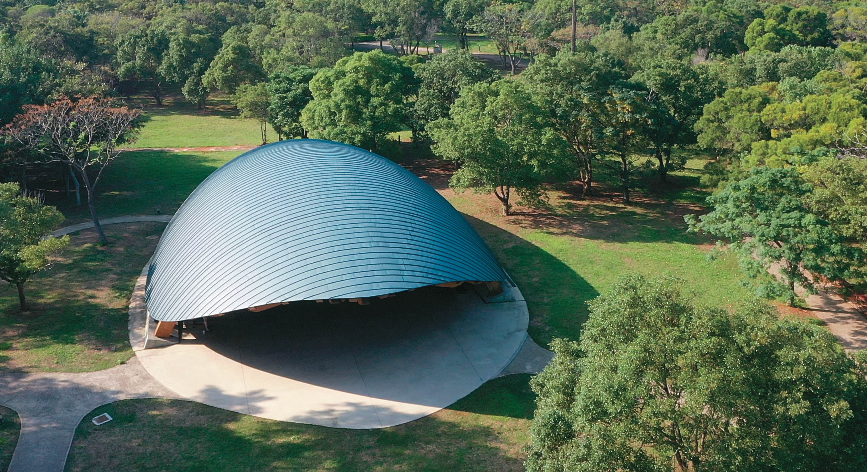 崙坪文化地景園區內，以展演聲音為主題的龜殼劇場像一片落葉躺在綠意簇擁的園區，與周遭環境完美交融。