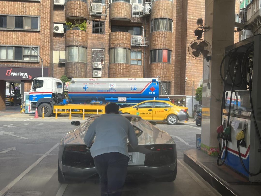 一名男子在台北市加油站用手推俗稱「大牛」的藍寶堅尼超跑，畫面在網路引發熱議。（翻攝臉書社團《爆廢公社二館》）