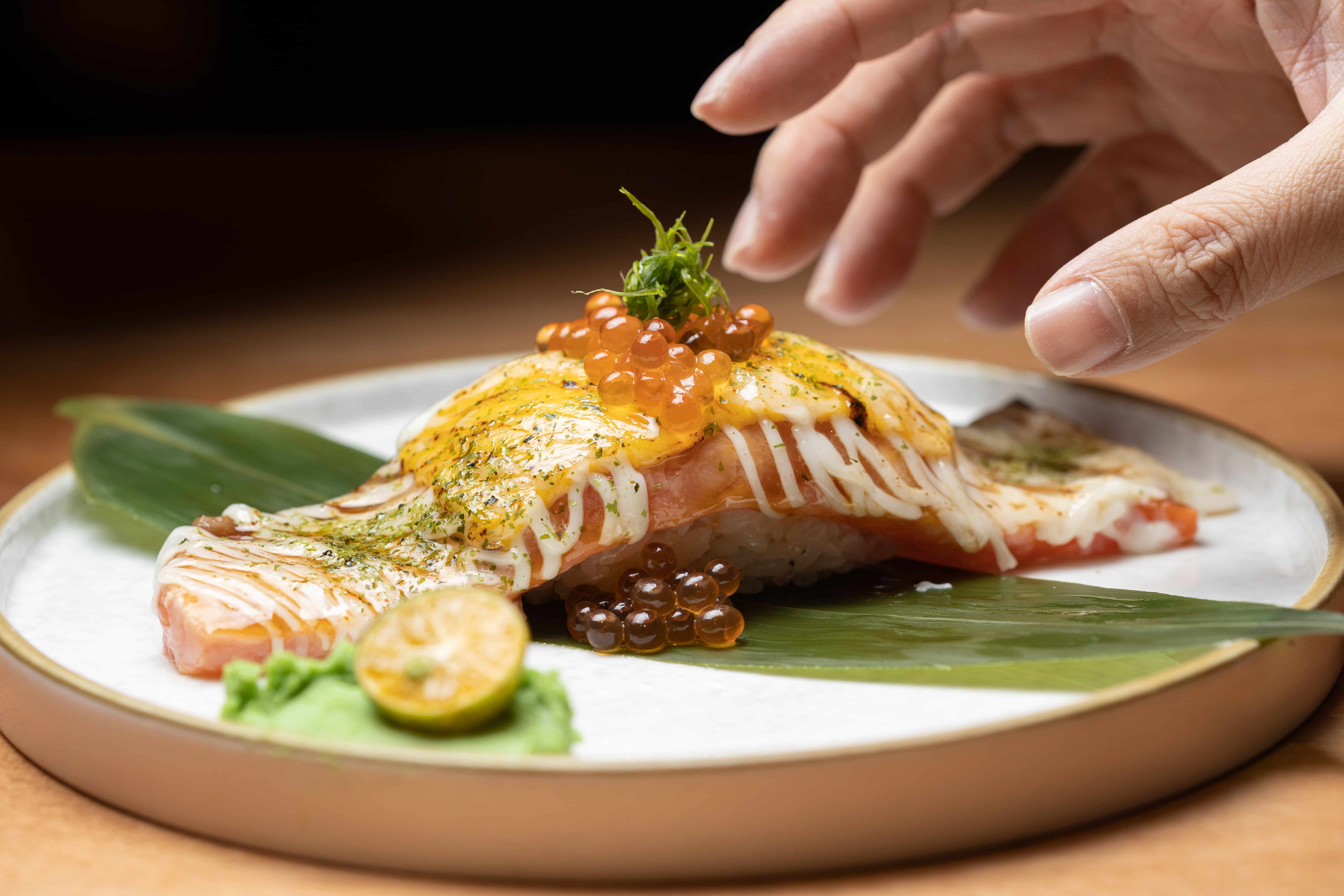 「巨型起司鮭魚握」一貫可以抵三貫！一旁的金桔搭配山葵，解膩又爽口。（198元／貫）