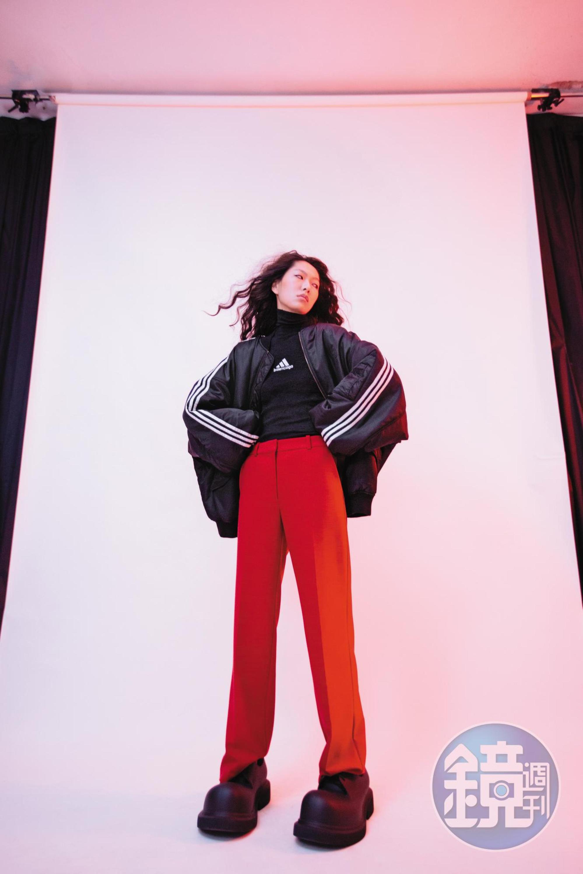 黑色oversize運動外套 價格店洽 by BALENCIAGA／黑色高領聯名上衣 價格店洽 by BALENCIAGA／紅色西裝長褲 NT$9,990 by MAJE／黑色大頭鞋 價格店洽 by BALENCIAGA