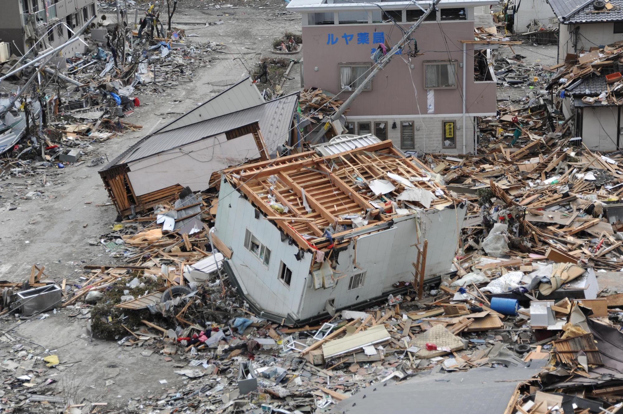 日本311大地震,在岩手縣大船渡市被巨大海嘯破壞四散的房屋。(翻攝維基百科)