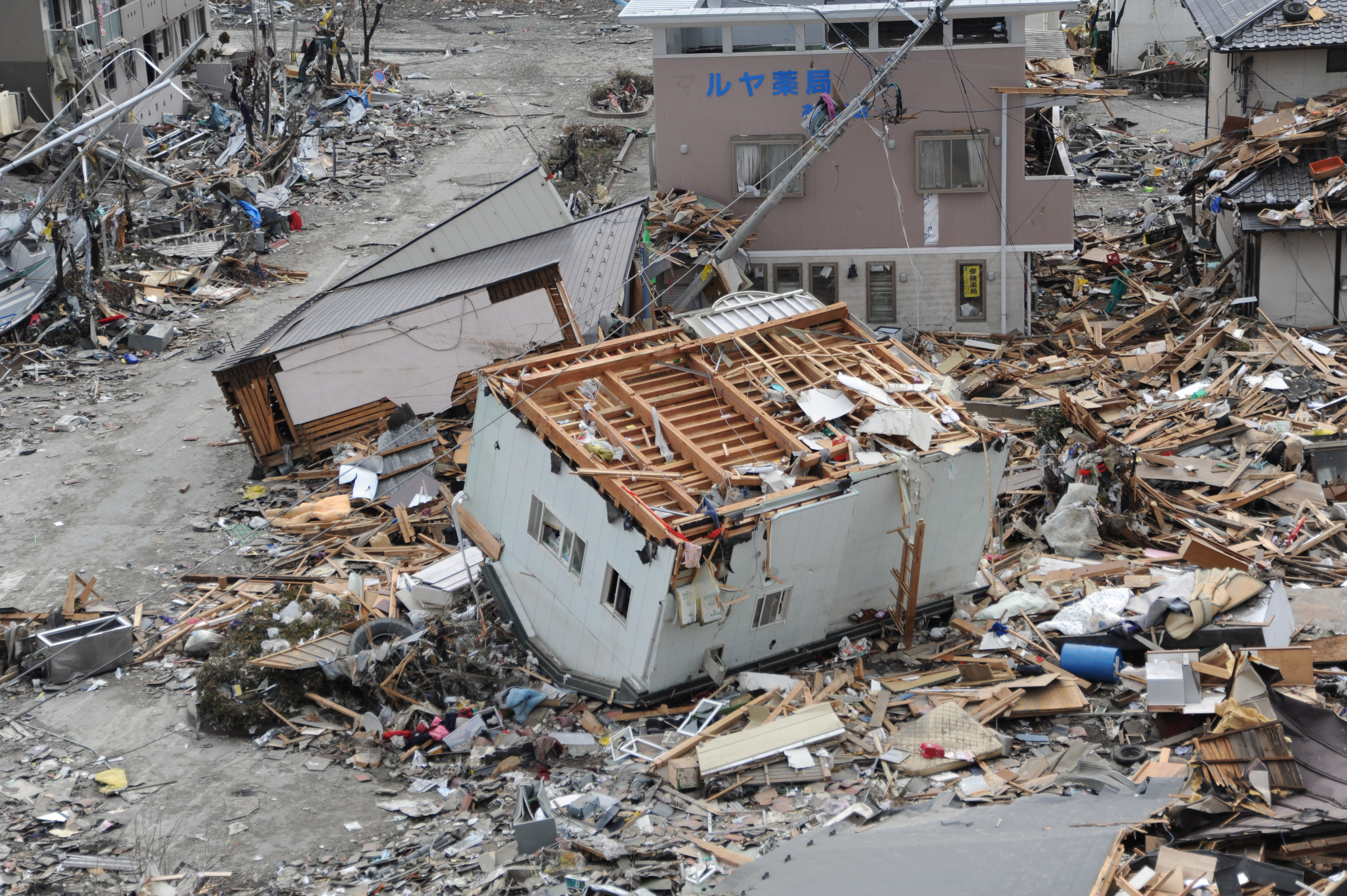 日本311大地震，在岩手縣大船渡市被巨大海嘯破壞四散的房屋。（翻攝維基百科）