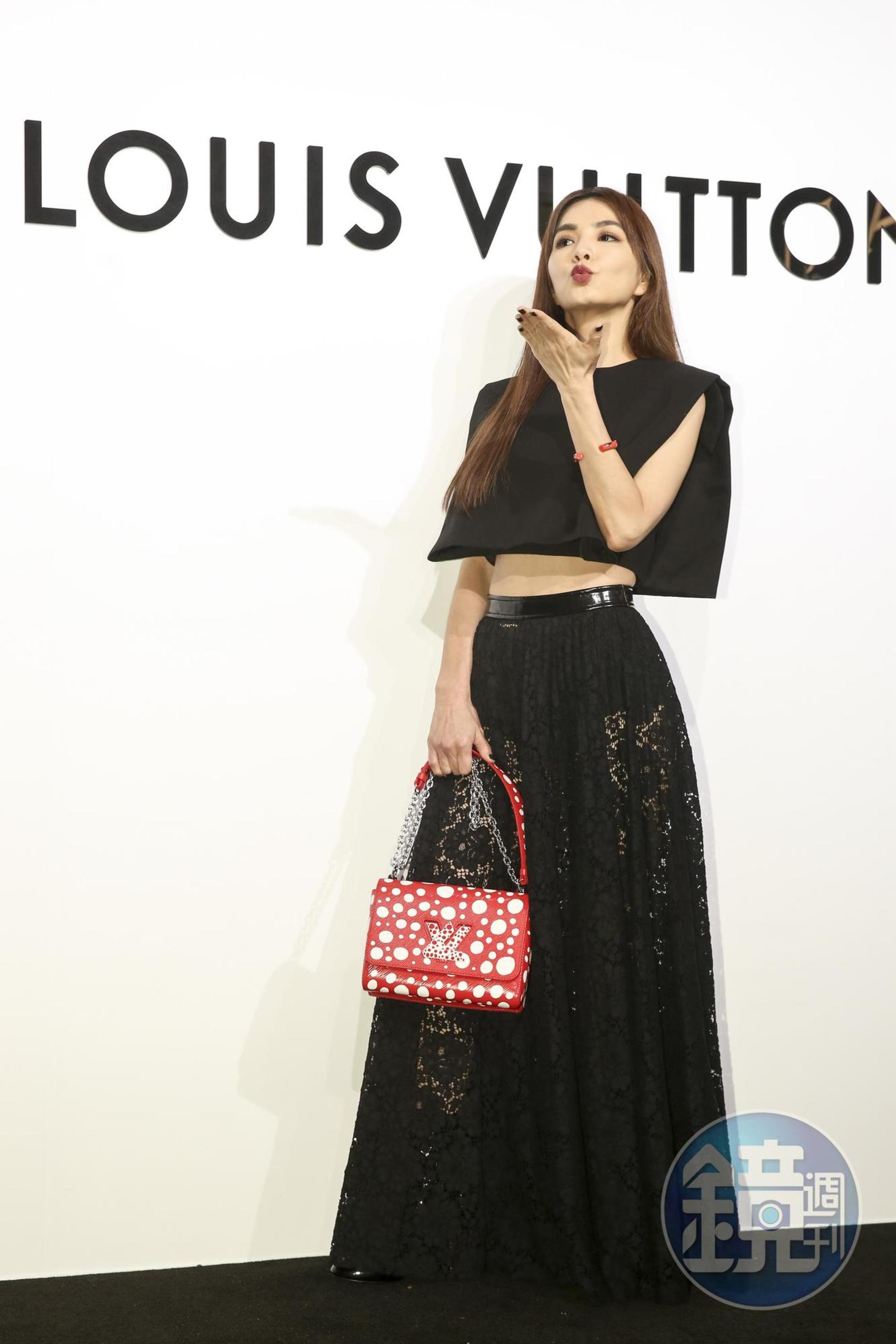 Ella身穿LV棉質斜紋布闊身上衣NT$83,500、花卉蕾絲半截長裙NT$158,000、LV X 草間彌生Twist MM紅色鍊帶肩背包NT$170,000。