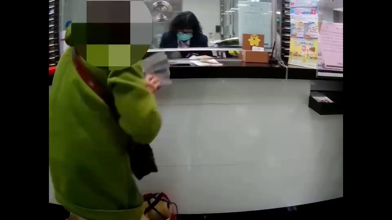 警方帶婦人到銀行把3百萬元現金存入銀行。(警方提供)
