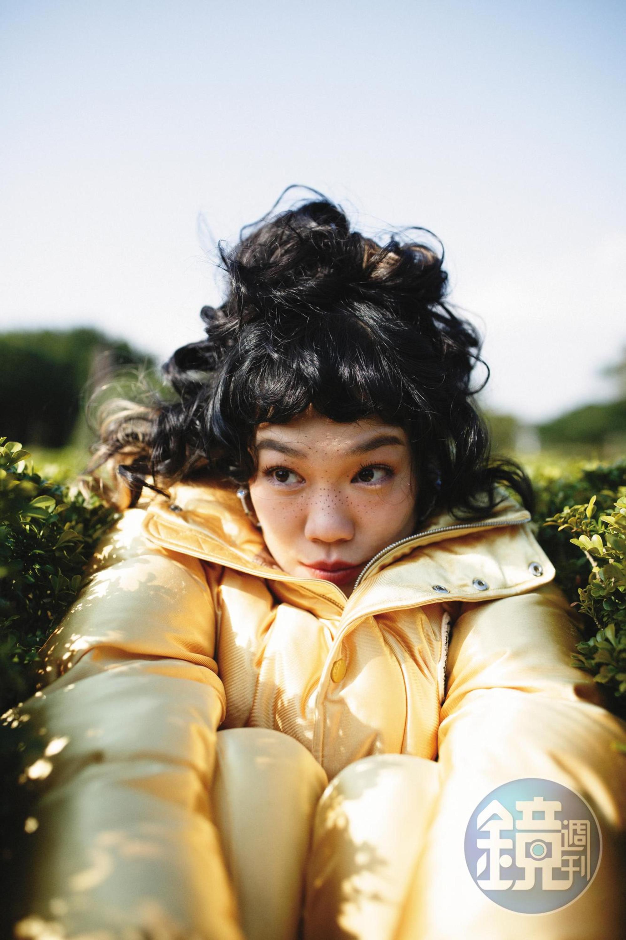 Keon金色短款冬季羽絨外套 NT$63,200 by 8 MONCLER Palm Angels／亮面運動褲 NT$20,200 by 8 MONCLER Palm Angels／藍色與綠色寶石圈形耳環 NT$7,900 by APM MONACO 