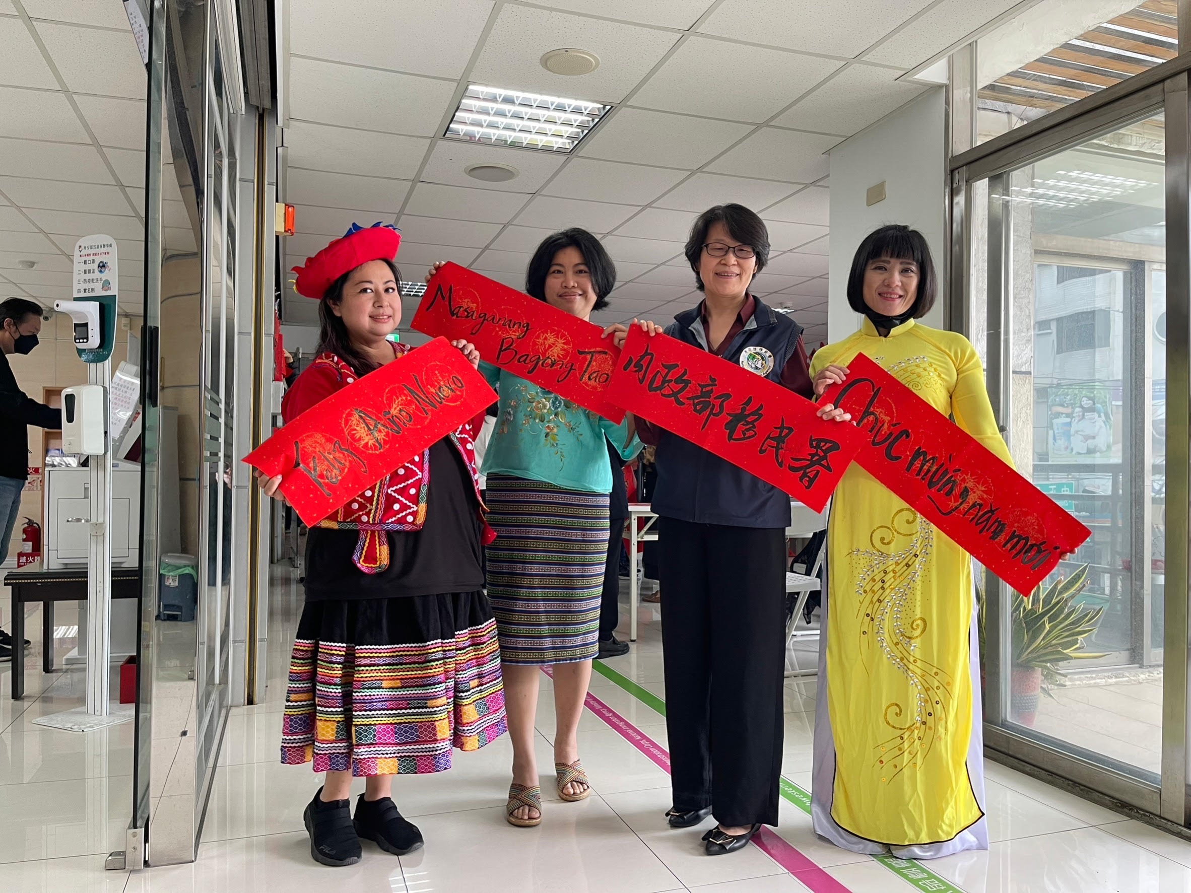 新住民與嘉義市服務站主任黃艷薰展示以母語寫的春聯，充滿年味。（移民署提供）