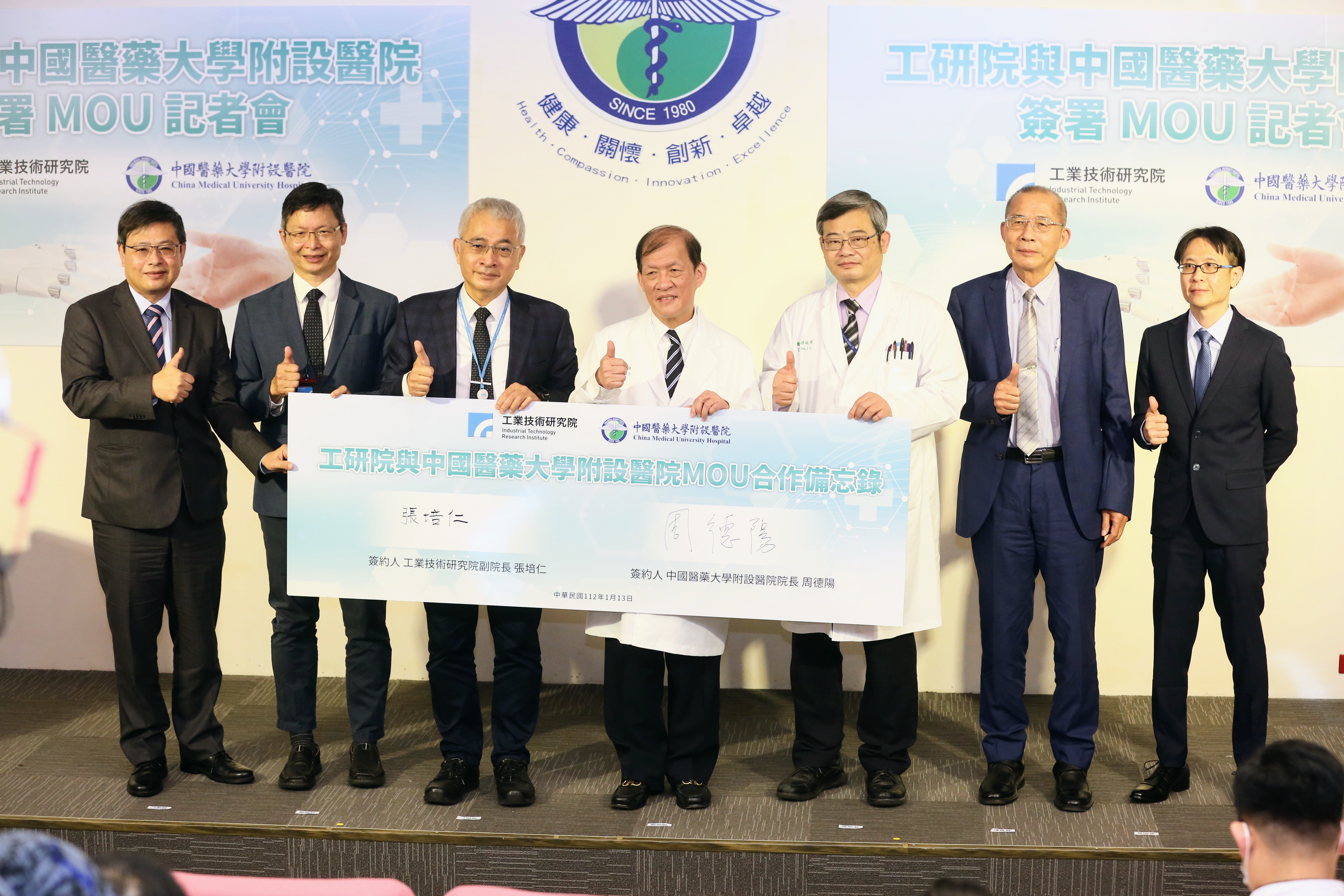 工研院副院長張培仁(左三)與中國醫藥大學附設醫院院長周德陽（右四）13日簽署合作備忘錄（MOU），運用鐿鈦、廣明等國內科技大廠在機器人技術將智慧醫院推向新高峰。