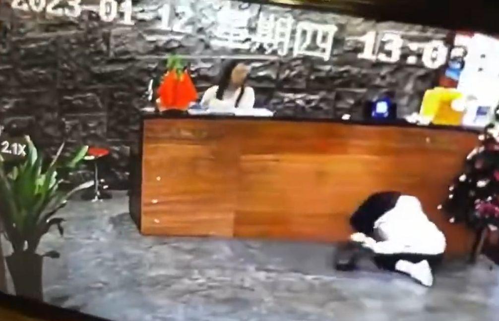 一名女子開門進入飯店大廳時,一不小心失足滑倒,摔了個狗吃屎。(翻攝自微博)