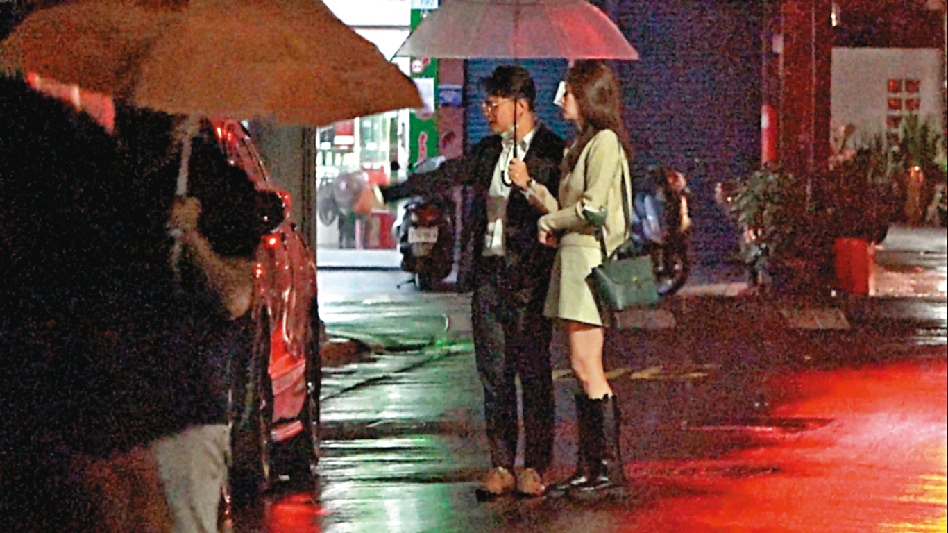 2023/01/15 01:26 餐敘到半夜後，2人共撐1把傘、邊走邊抽菸，謝泊泓甚至不顧官員身分就違法隨手亂丟菸蒂。