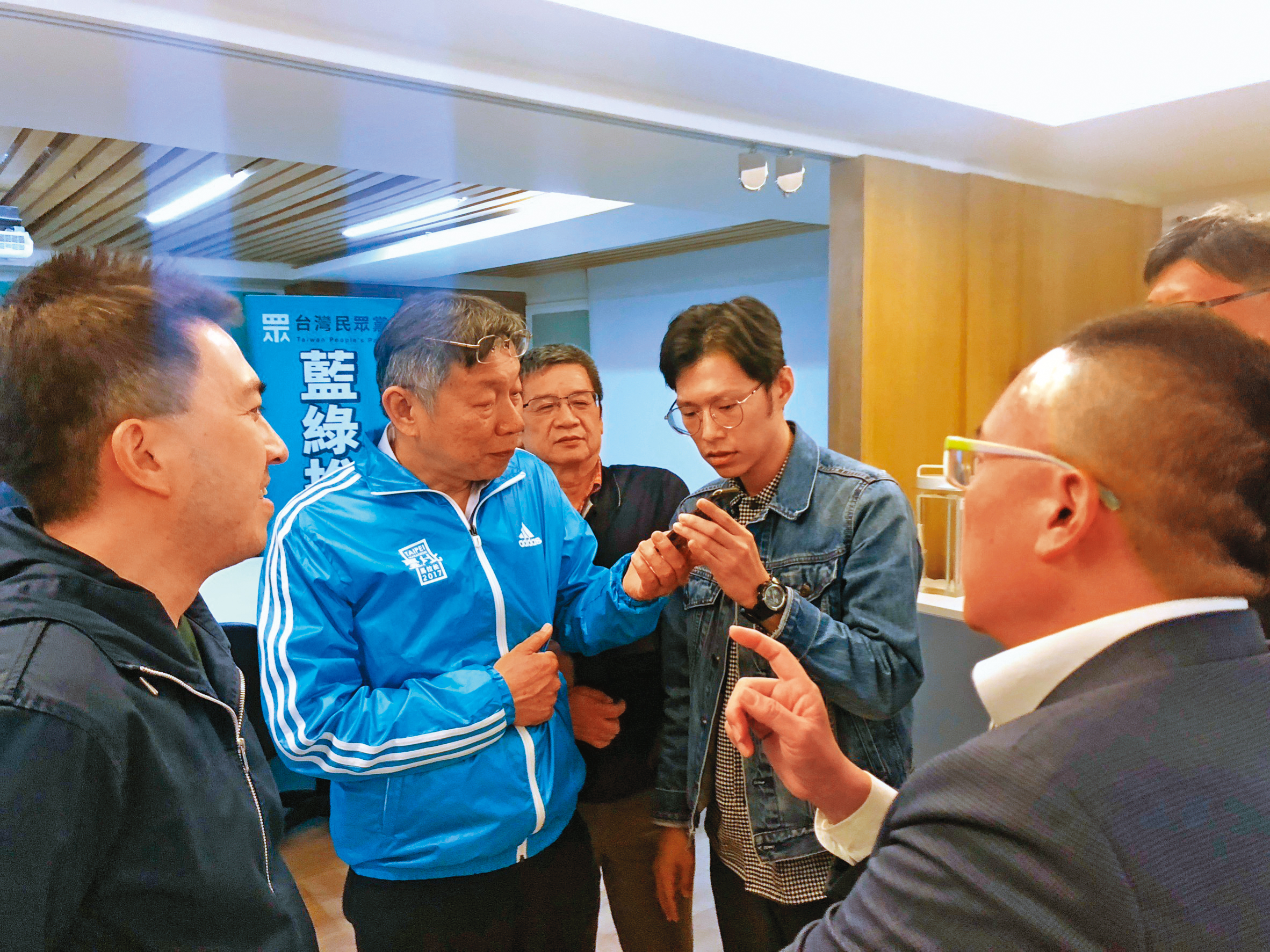 謝泊泓（拿手機者右）是柯文哲（拿手機者左）核心幕僚，2020年大選開票之夜本刊專訪柯時，他更是少數陪同受訪的幕僚。（黃驛淵攝）