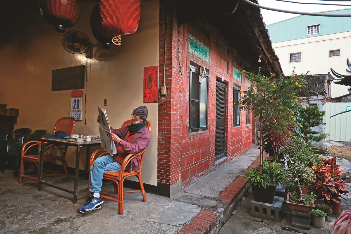 清晨的開庄伯公廟前，老人悠閒的看報紙。