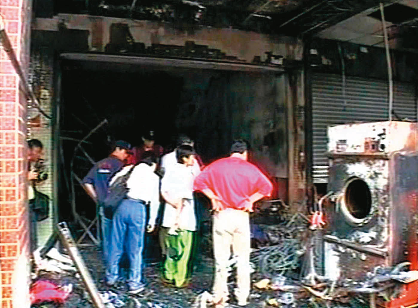 警消撲滅火勢後進入洗衣店蒐證，全力追查火災的原因。（東森新聞提供）