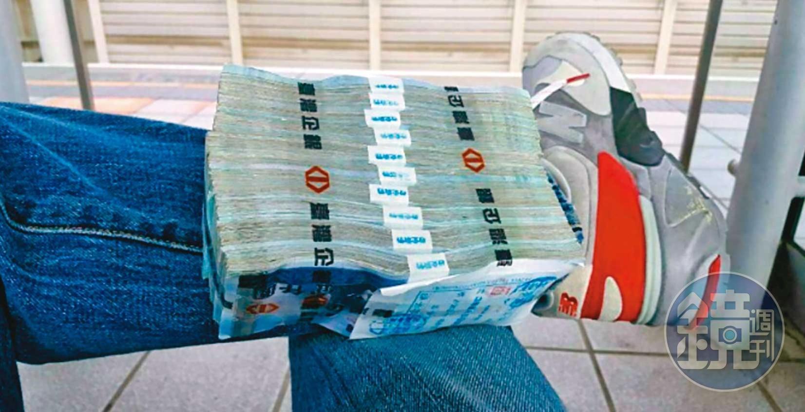 為了取信被害人,張錦生故意將大筆現金放在腳上拍照炫富。(讀者提供)