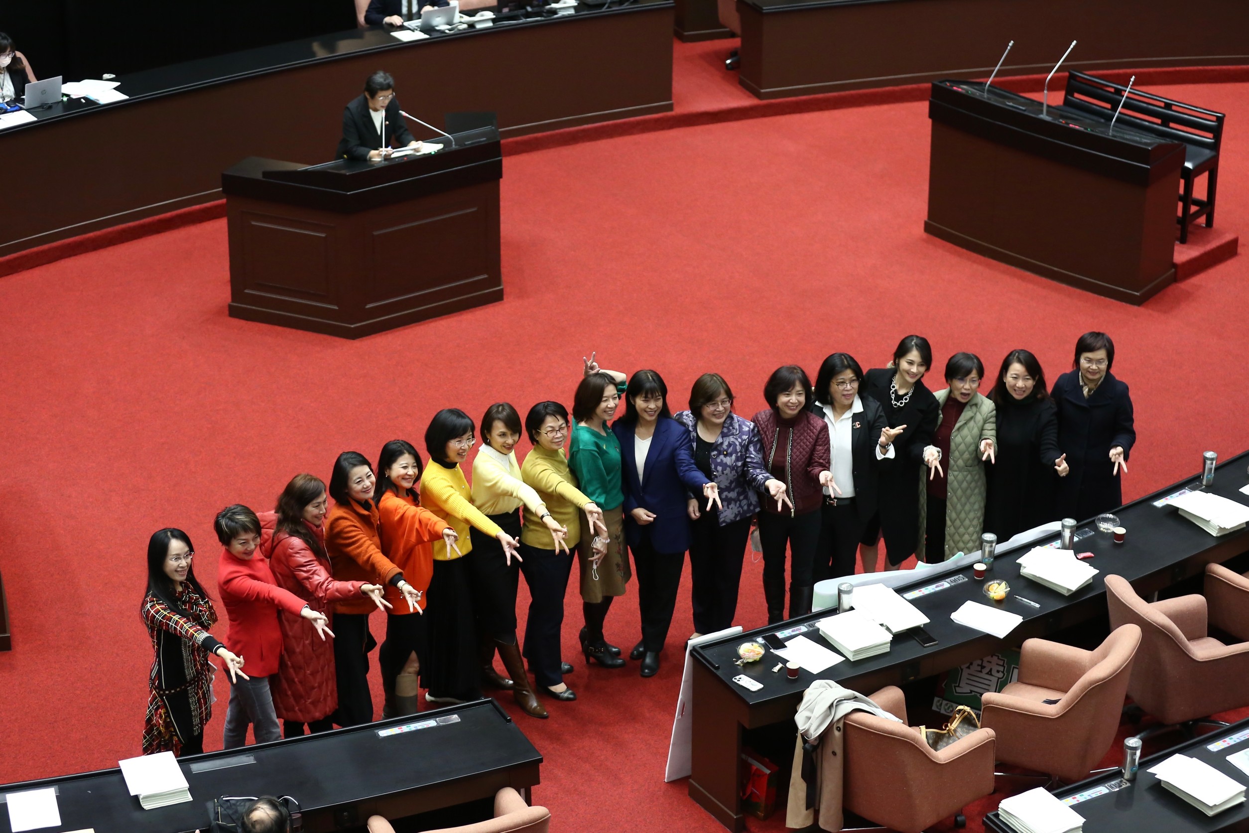 民進黨女立委們大合照，比出時下流行的「倒V」手勢，服裝還是「彩虹色階」。