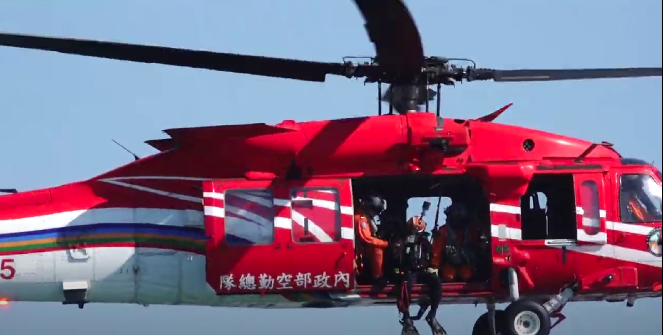 空勤總隊隊員以吊掛方式準備垂降入海救人。(翻攝畫面)