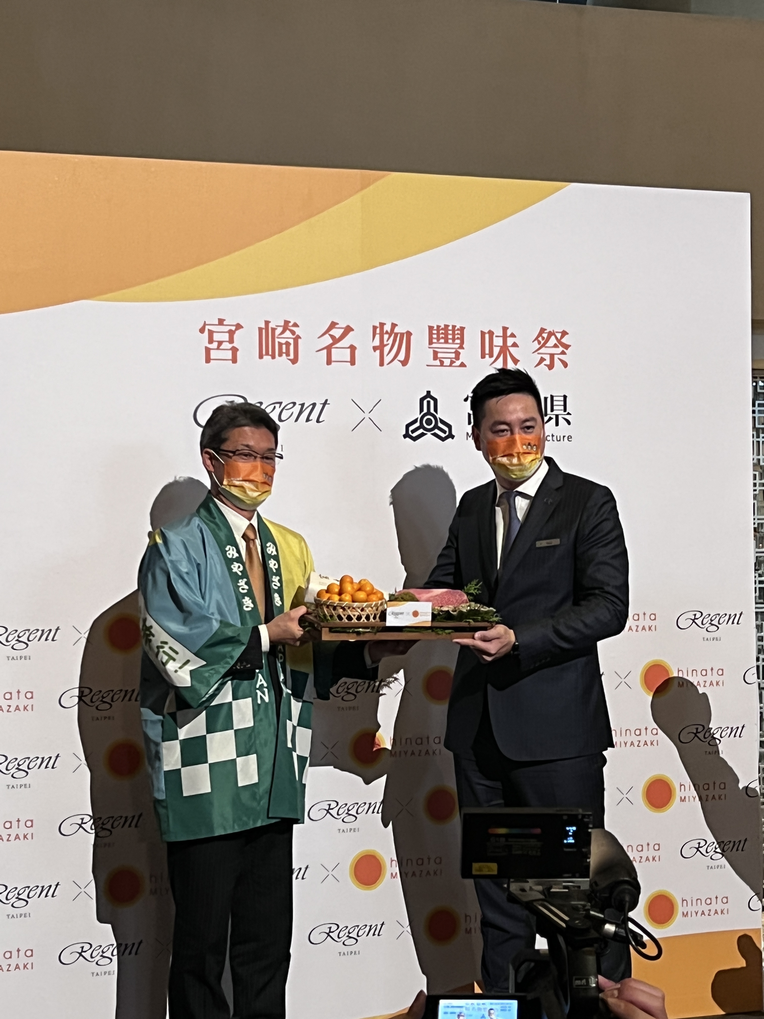 宮崎縣知事河野俊嗣（左）於記者會上，代表宮崎縣致贈名物禮籃給台北晶華酒店餐飲部副總經理羅明威（右）。