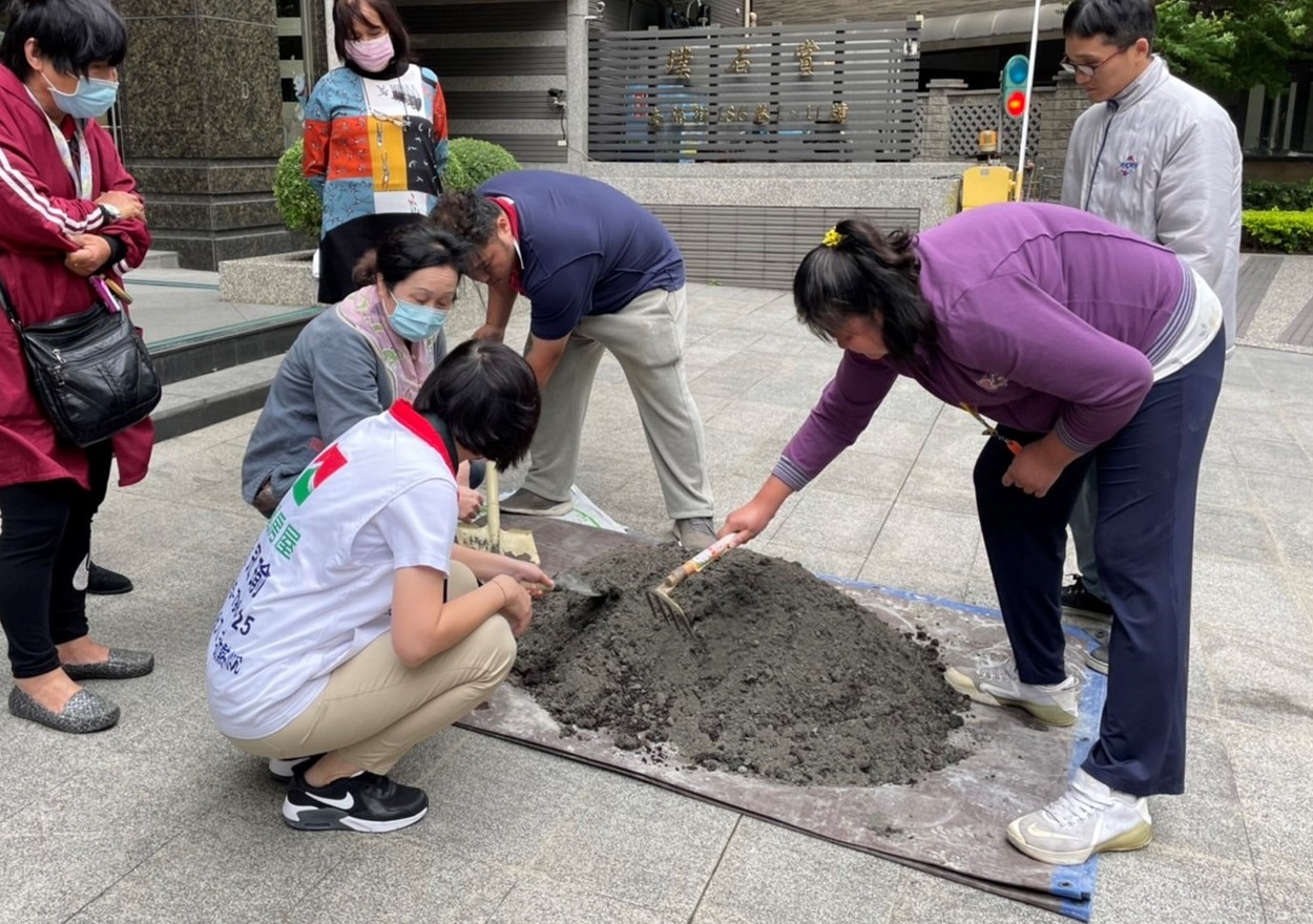 社區居民與信義房屋房仲一起翻土,種下花草。(信義房屋提供)