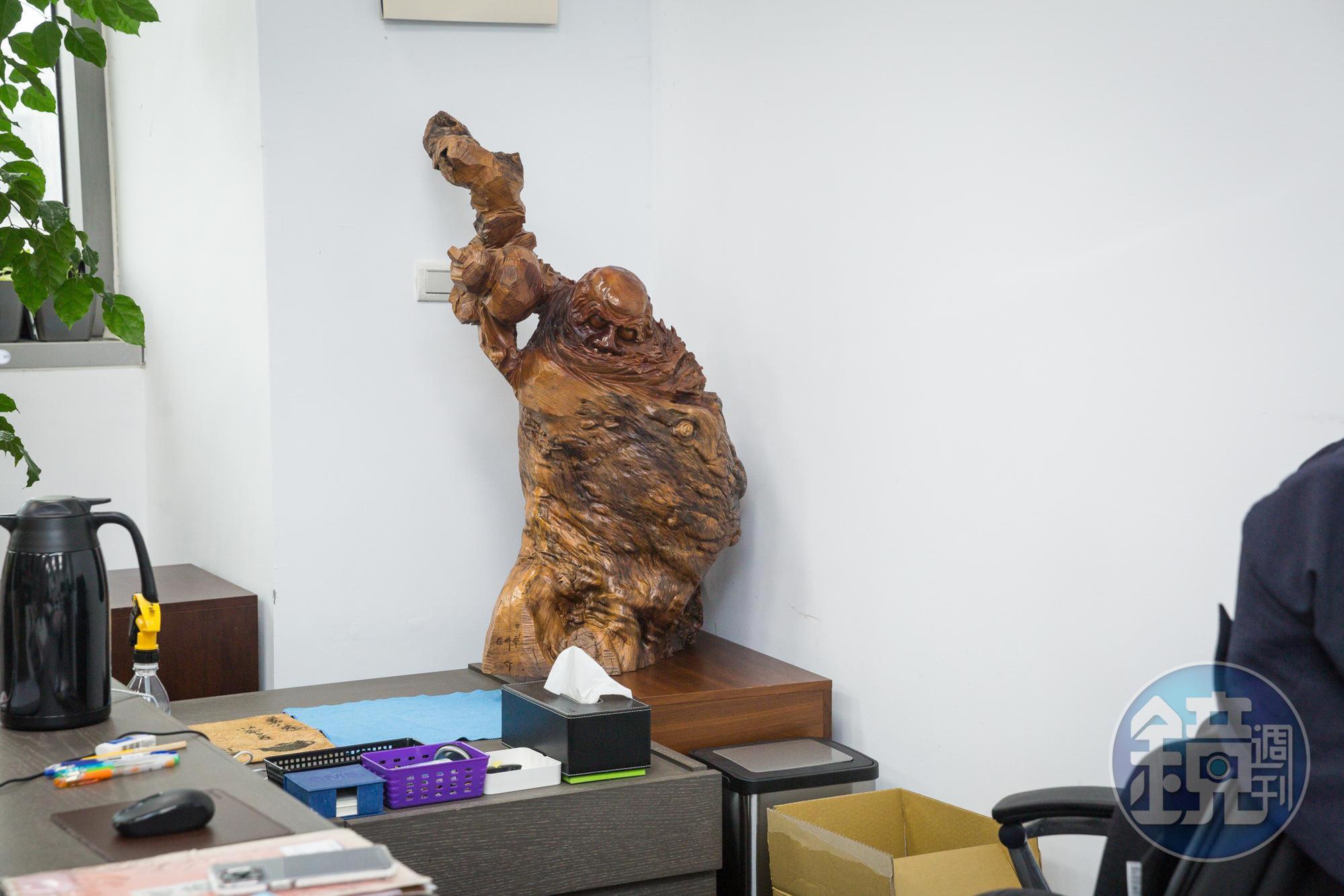 廖育斌將老家改建砍下的老荔枝樹雕刻成達摩像，陪伴自己辦公。