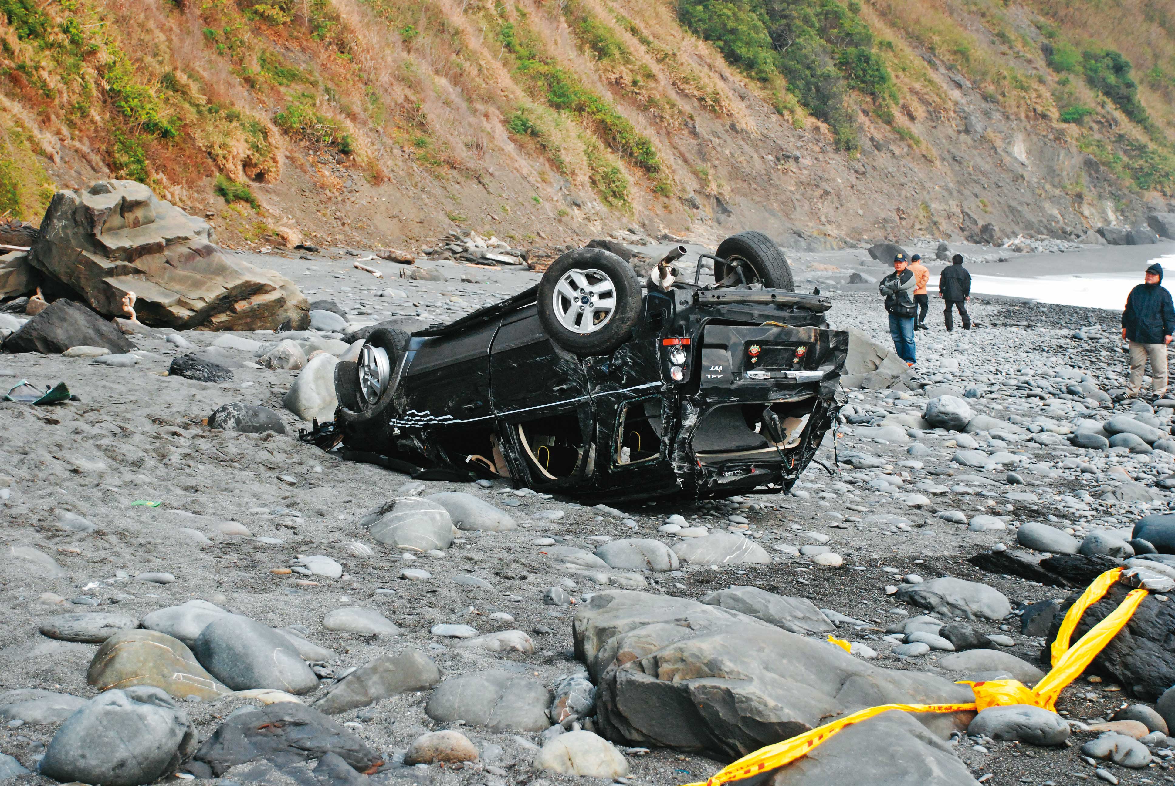 台東警方在大武鄉一處斷崖下的石灘上，發現四輪朝天的休旅車。（讀者提供）