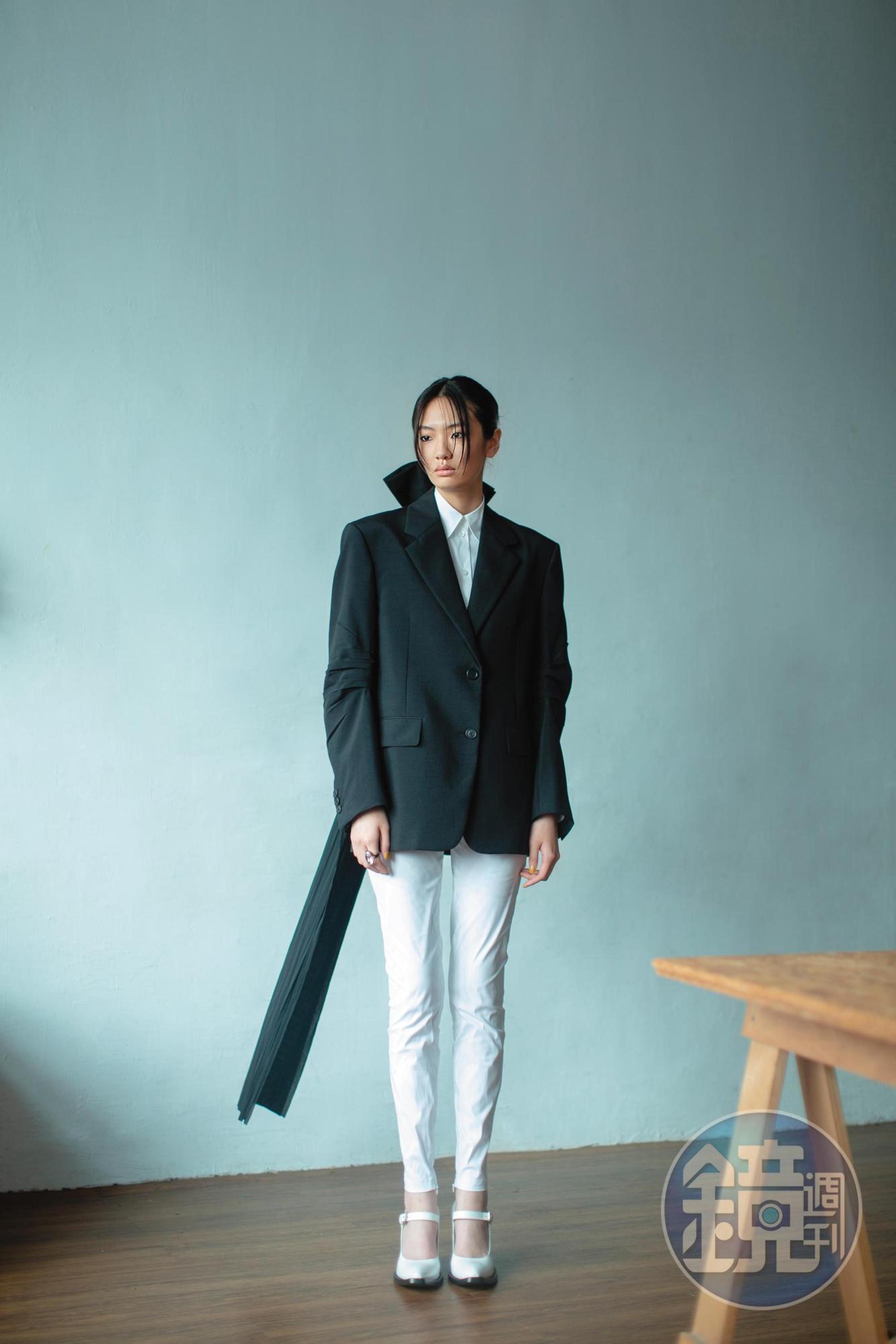 黑色西裝外套 價格店洽 by PRADA／白色襯衫 價格店洽 by PRADA／白色長褲 價格店洽 by PRADA／白色繫帶瑪莉珍高跟鞋 價格店洽 by PRADA／Harmonia戒指 NT$8,000 by SWAROVSKI