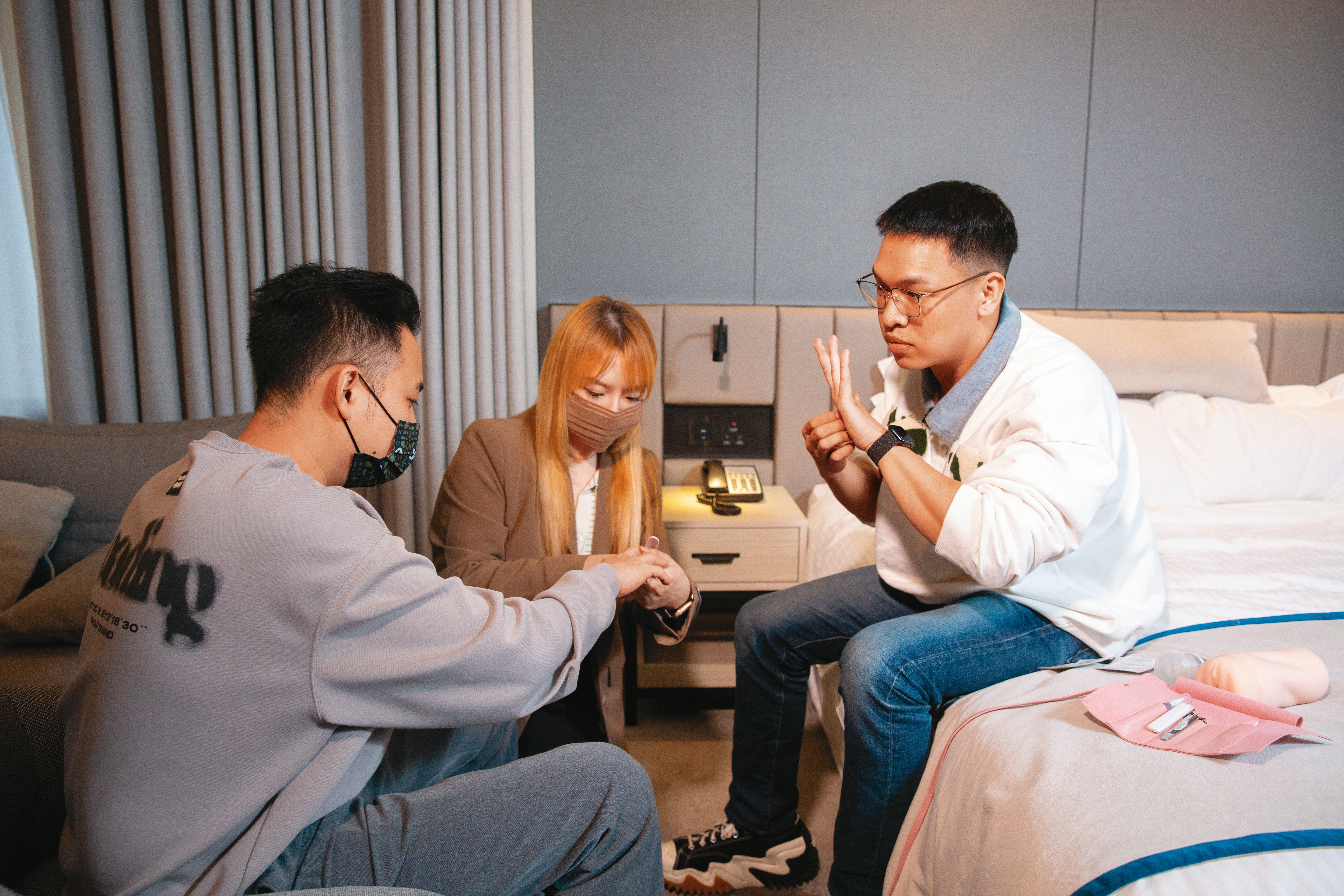 綽號阿桂（左）的男子第一次上金手指家教課，Oreo（右）與女助教（中）正教他如何修剪指甲及戴指險套。