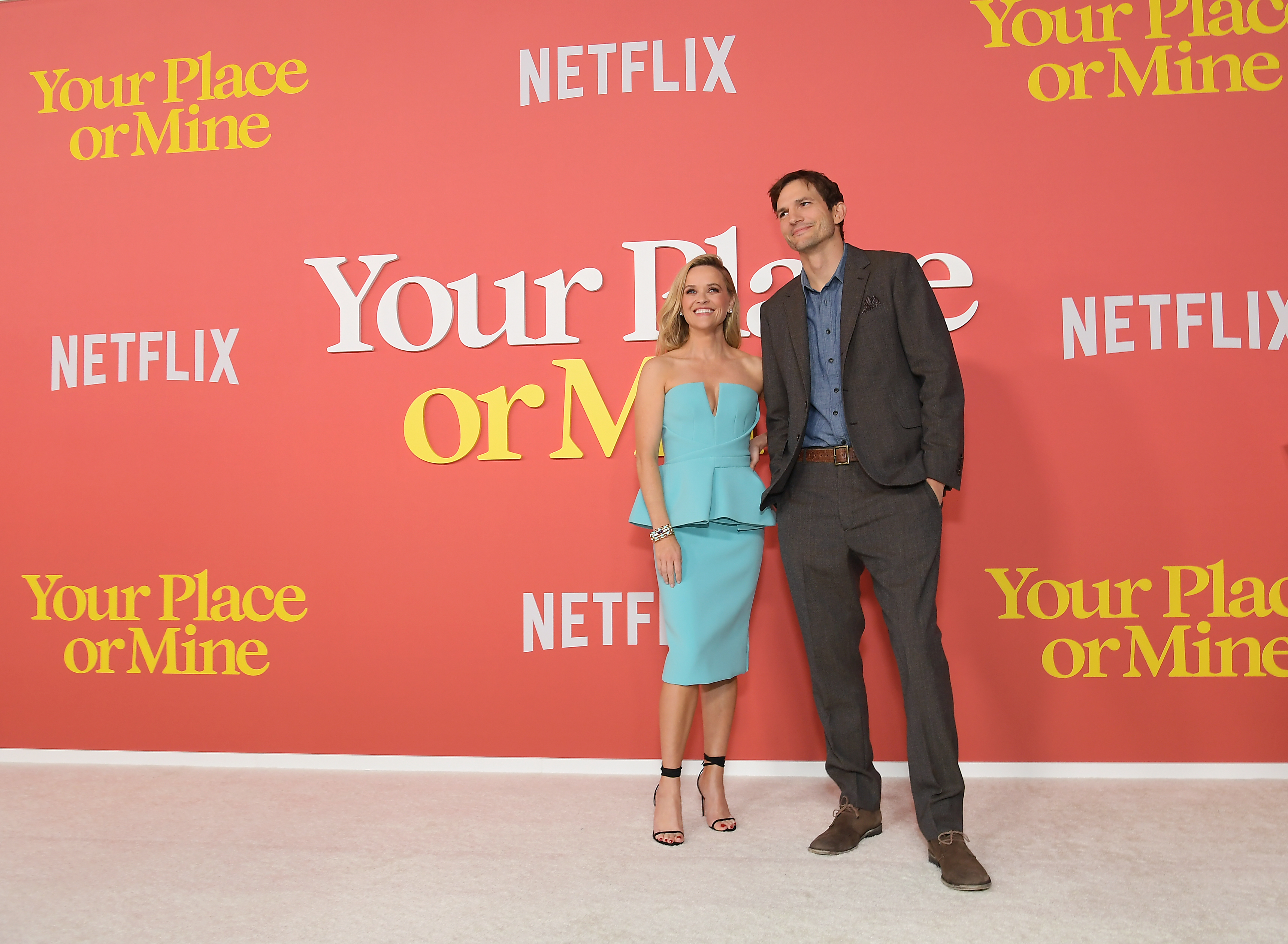 艾希頓庫奇（右）與瑞絲薇斯朋（左）分明演的是浪漫喜劇，但在首映紅毯合照看起來就很尷尬。（Netflix提供）