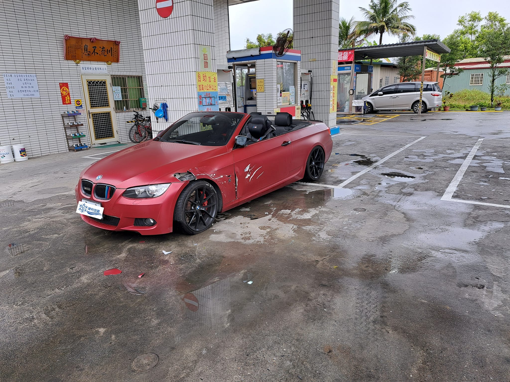 紅色BMW到花蓮某加油站加油時,遭曳引車擦撞騎上去。(翻攝自爆廢公社二館)