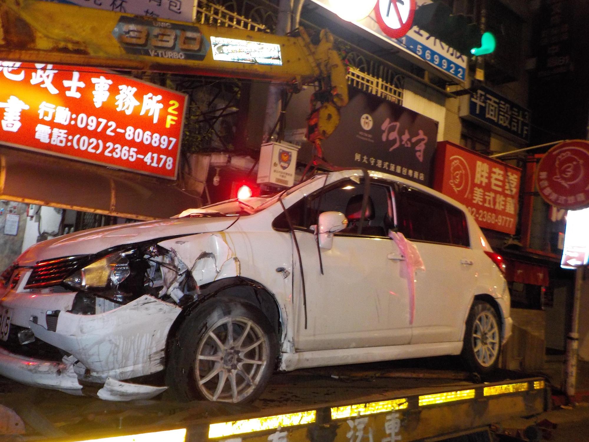 女酒駕自撞路口、車頭撞毀。（翻攝畫面）