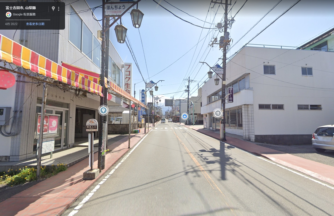 日本山梨縣富士吉田市的「本町二丁目商店街」是知名打卡景點，許多遊客常站在路中央，以富士山為背景拍下網美照。（翻攝Google Maps）