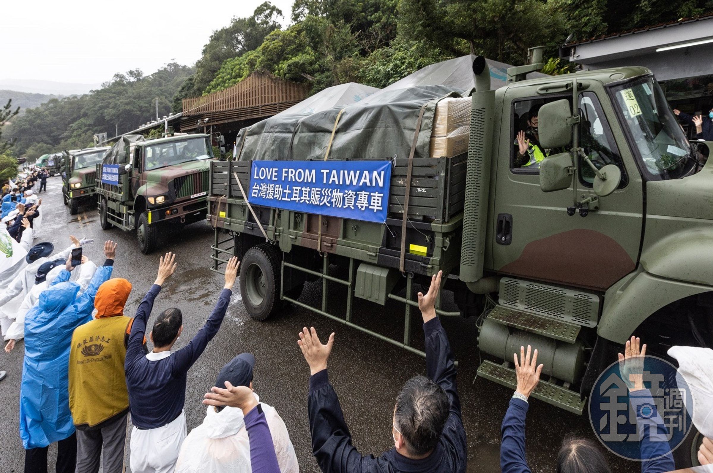 志工及民眾向國軍載運土耳其賑災物資車隊揮手致意。（慈濟基金會提供）