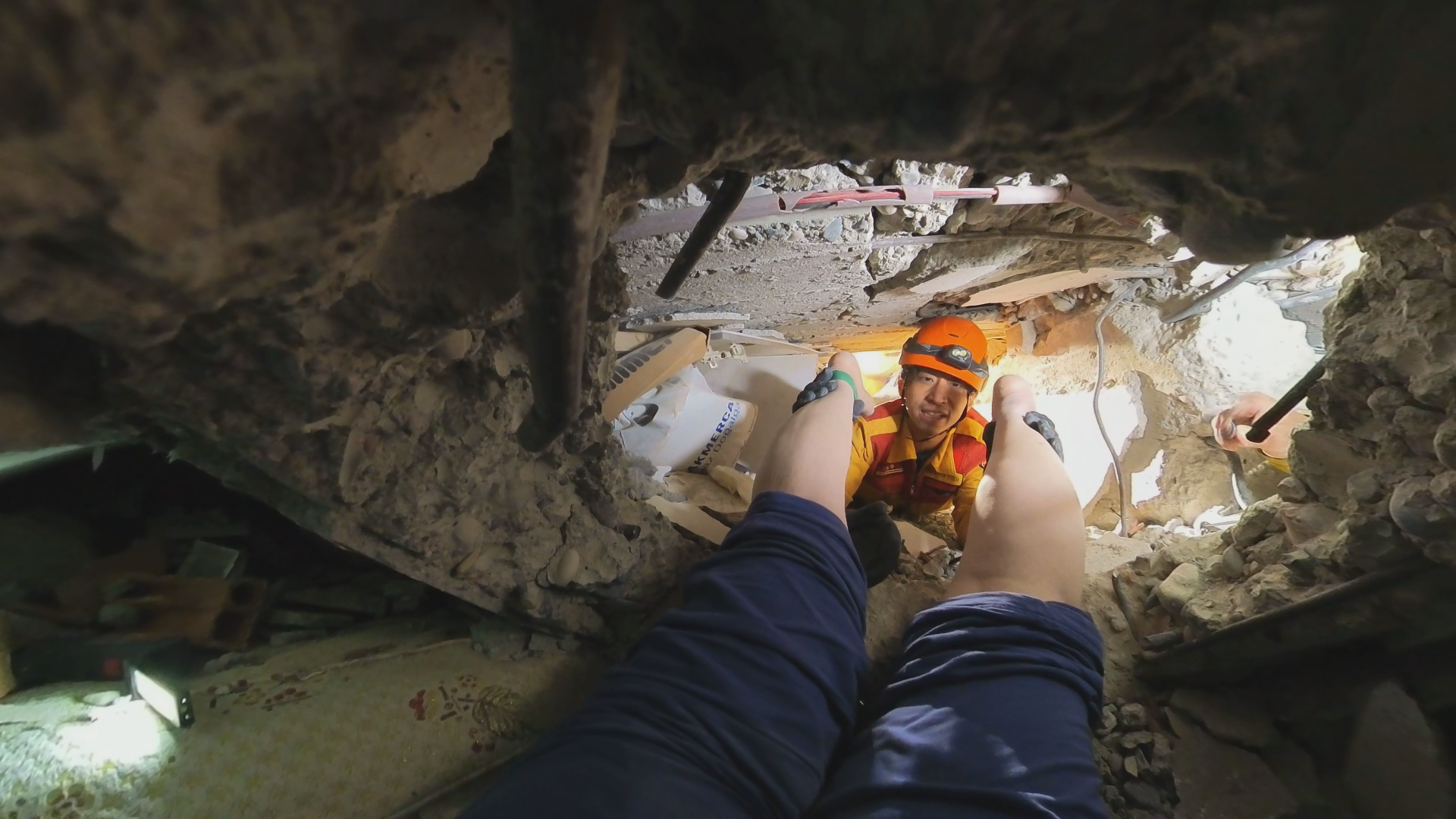 土耳其民眾呈現趴姿受困在鋼筋水泥中，搜救隊只能從後方協助拉出。（台灣國際特種搜救隊提供）