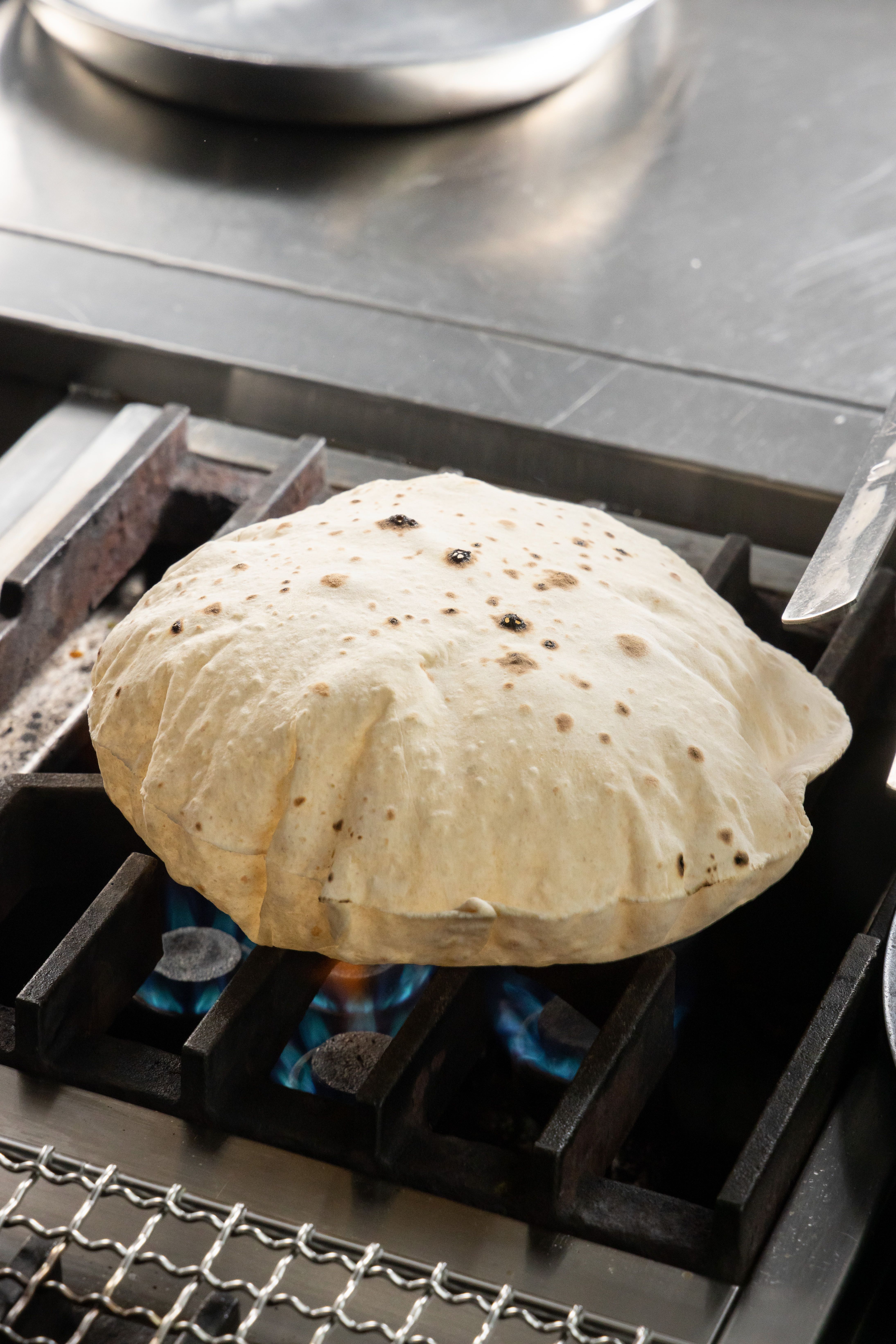 用印度全麥麵粉揉製的「烤麥餅」（Roti），不經過發酵，上桌前得先一個一個用火烘烤至膨起。