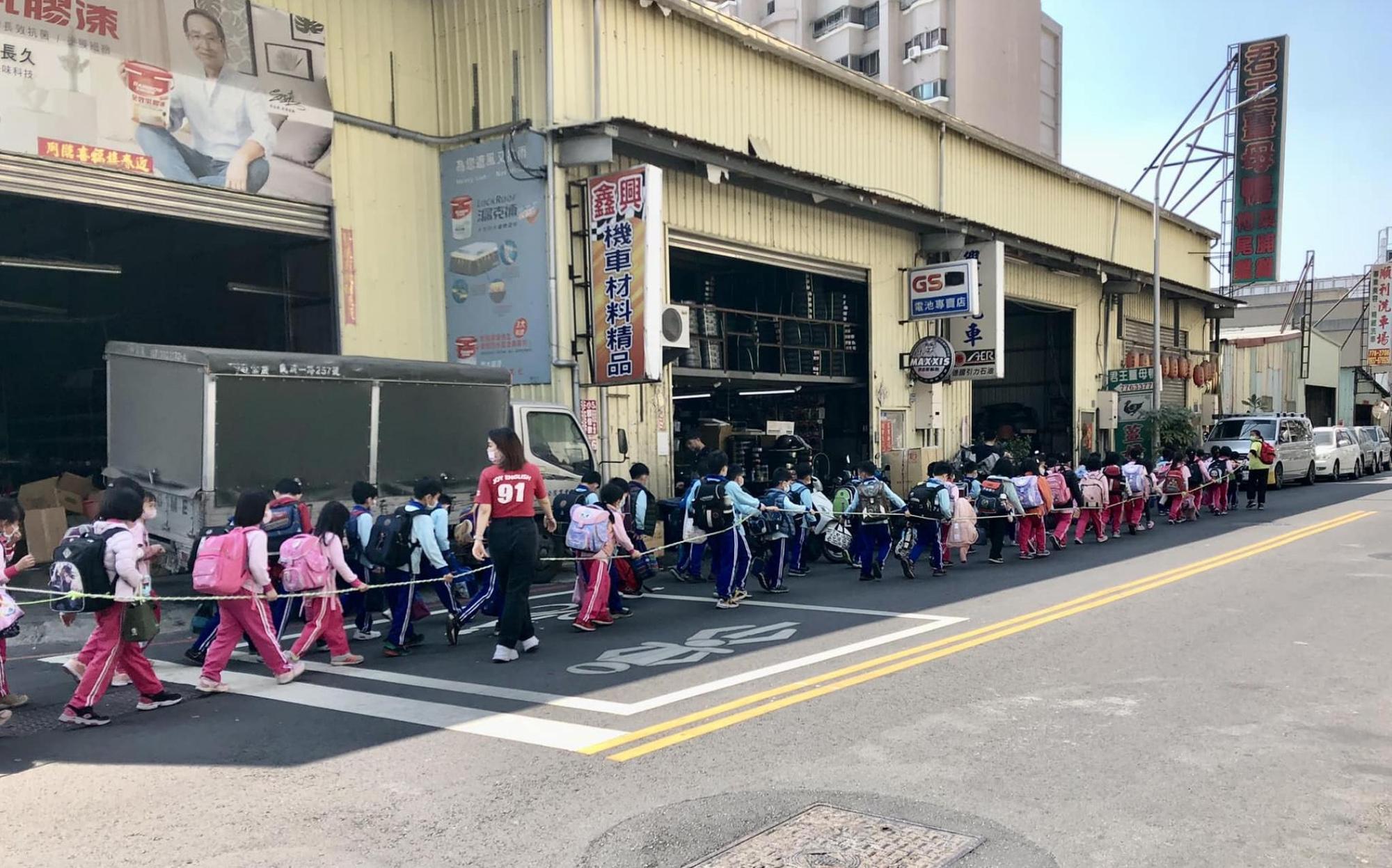 國小學童拉著繩走在馬路上與車爭道，照片掀起熱議。（翻攝自Cheap臉書）