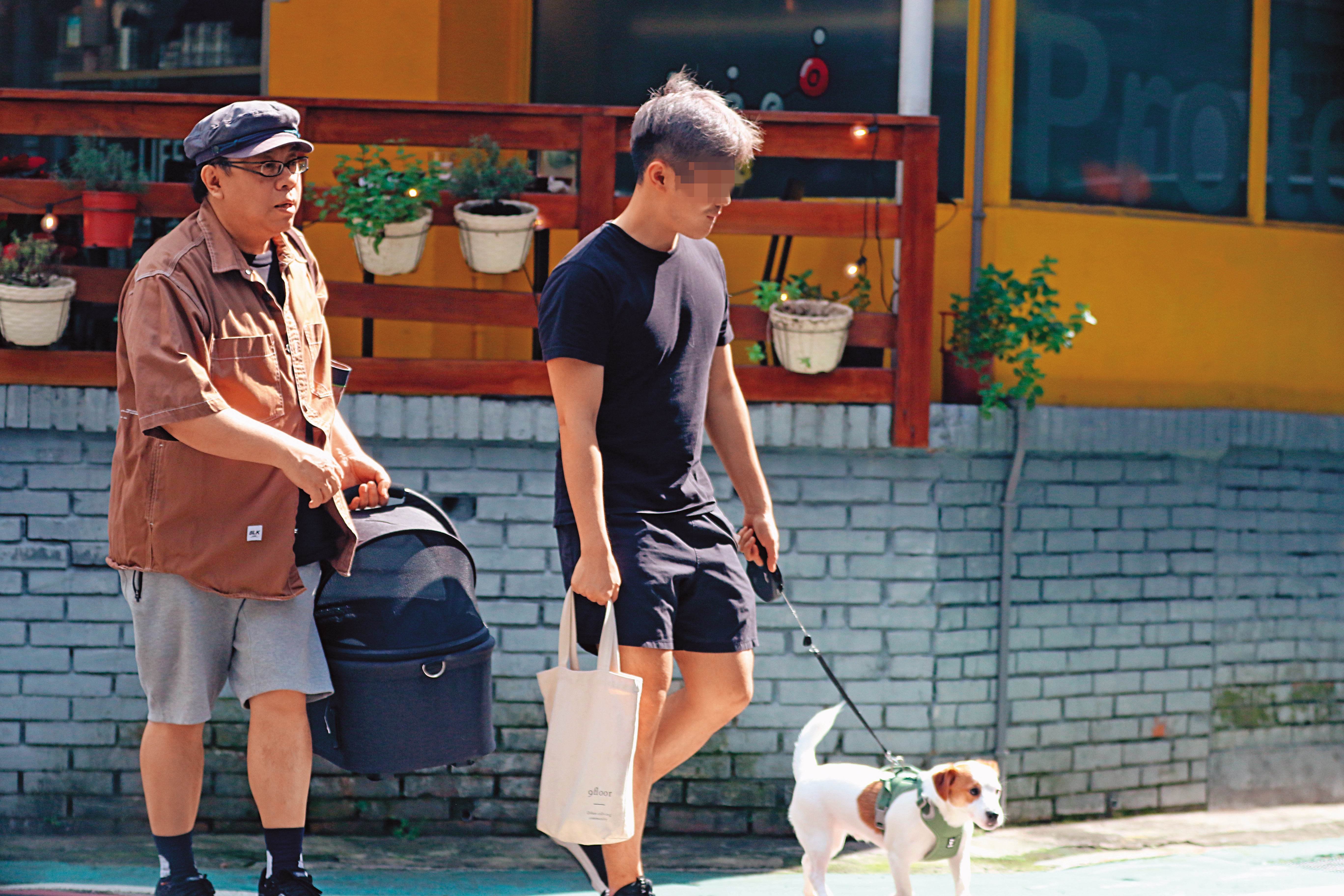 2/13 12：25 蔡康永提著狗籃走在帥壯男後面，對方的胸肌厚實，身材健壯。