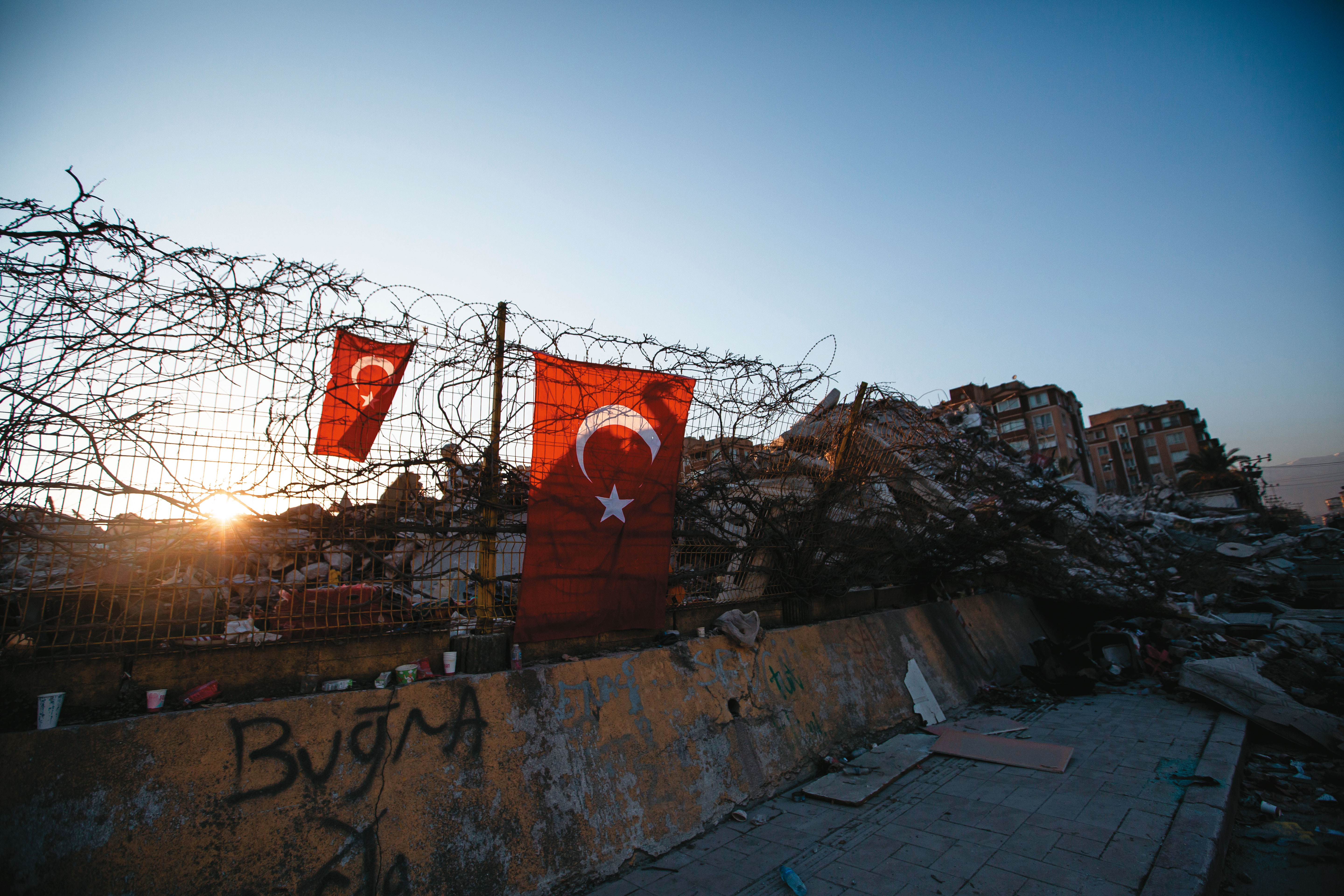 強震震垮大量樓房，災民在鐵絲網上懸掛土耳其國旗、等待朝陽。（鄒保祥攝）