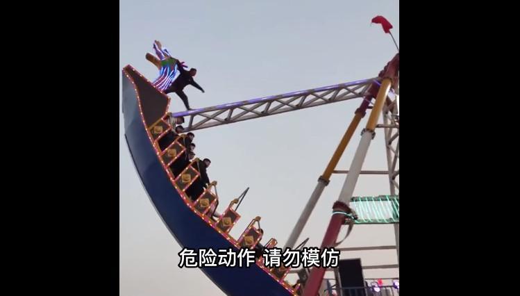 一名男遊客在中國山西一座遊樂園搭乘海盜船，沒想到在遊客設施擺動時竟在無防護措施下站到船頭。（翻攝微博@新聞晨報）